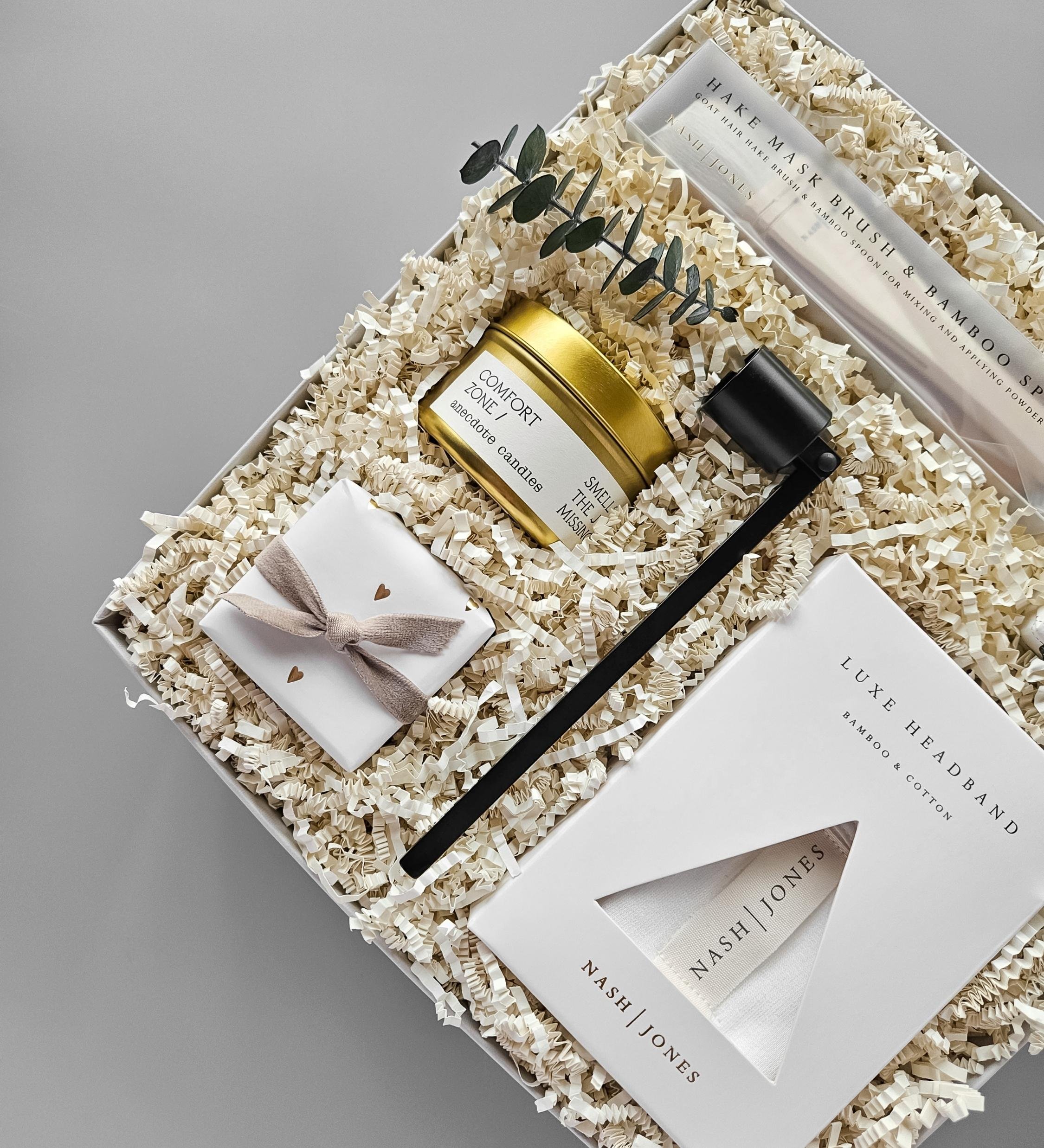 Relaxation gift box for her including bamboo headband, lavender bath bomb, marine face mask, candle, mask brush, and candle snuffer.