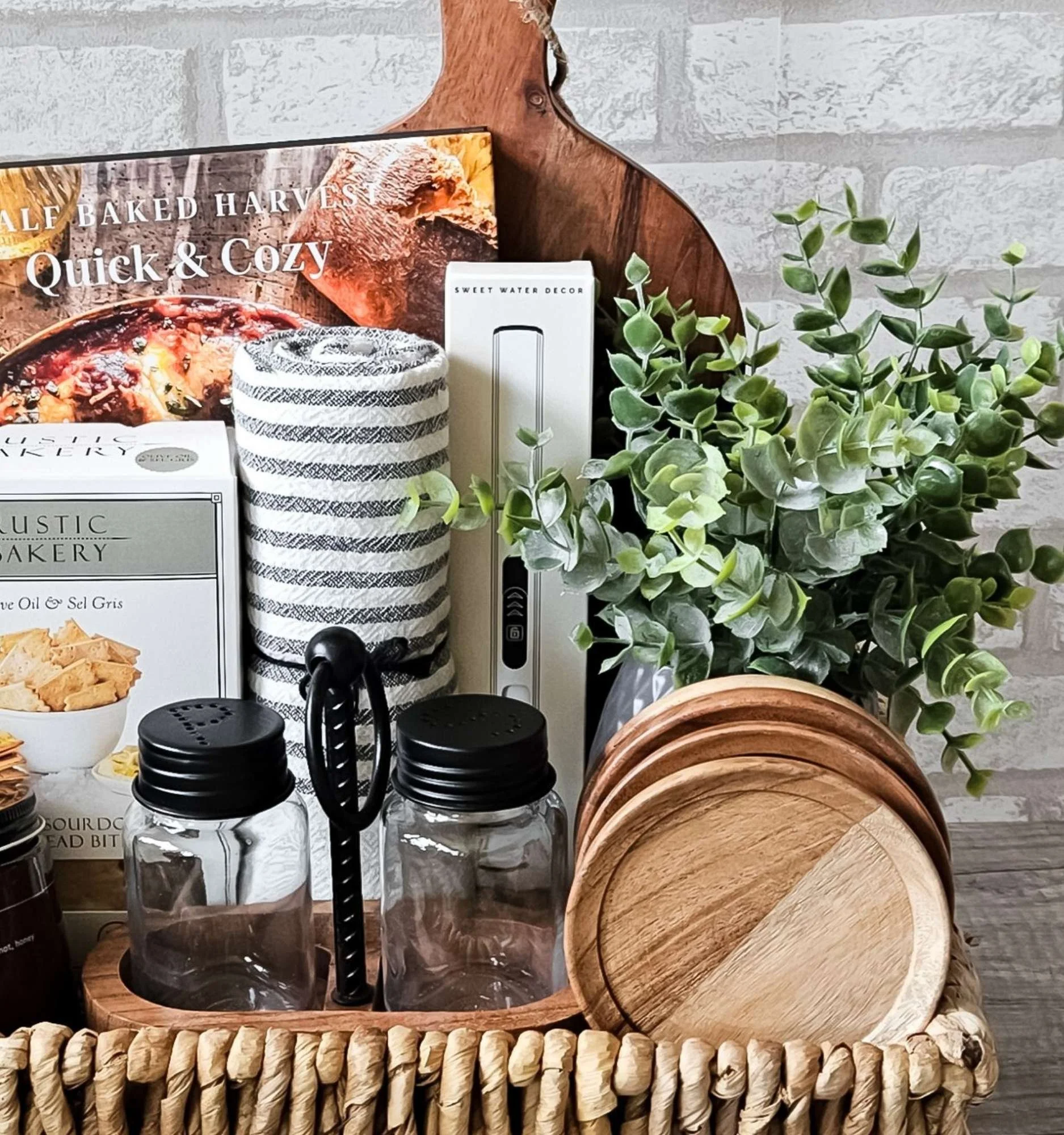 Artisan rustic gift basket with cookbook, candle, towel, lighter, wood pieces, and gourmet flatbreads—perfect for closings, weddings, and housewarmings.
