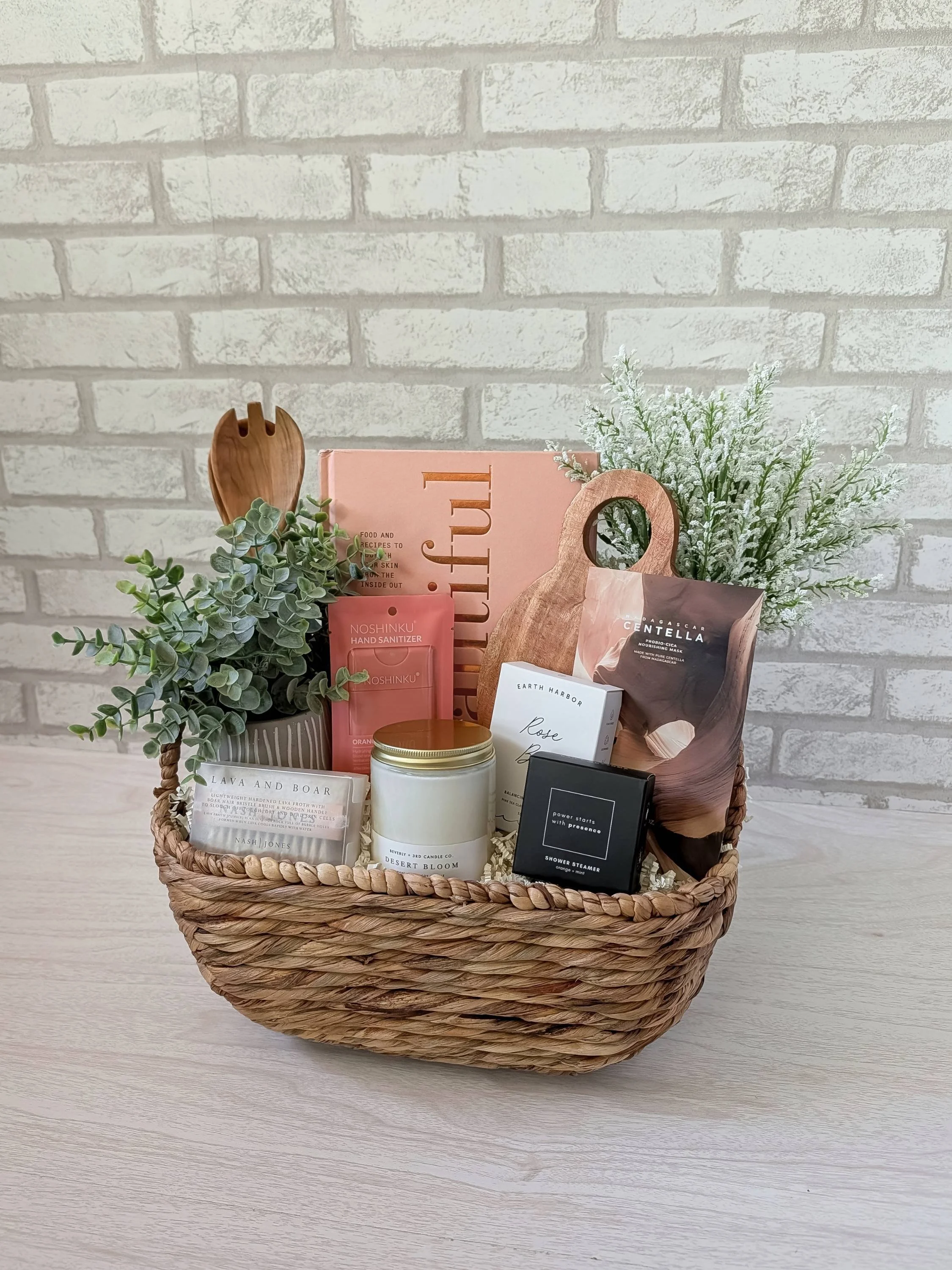 Stylish gift basket for her with Eat Beautiful cookbook, rose facial soap, skincare hand sanitizer, lava and boar brush, sweet orange + mint shower steamer, candle & skincare-inspired pampering gifts.