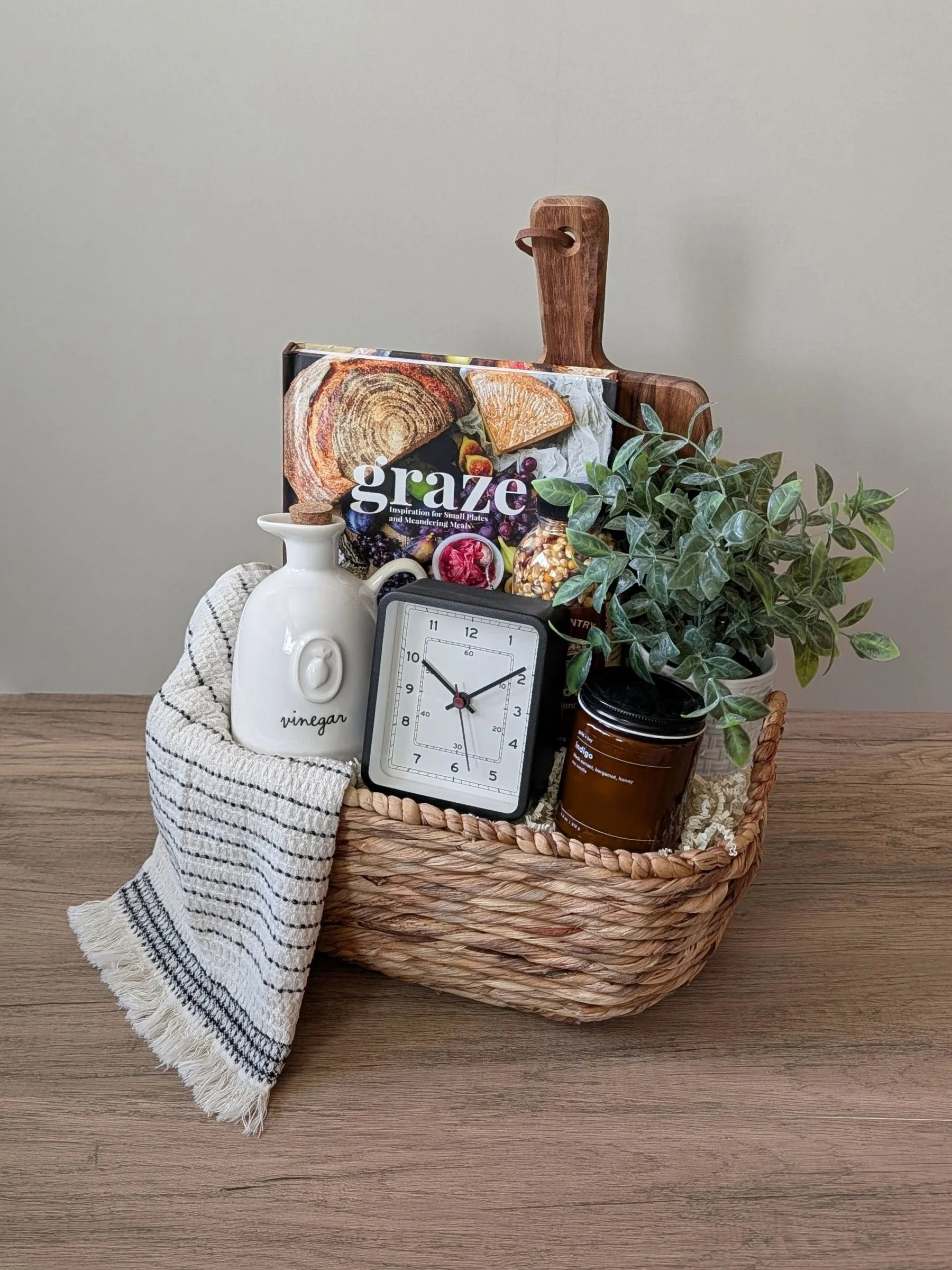 A cozy, rustic housewarming gift filled with thoughtful essentials for settling into a new space. This custom basket features a mix of practical favorites and elevated home details — perfect for welcoming someone into their next chapter with warmth, 