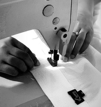 Person sewing fabric with a sewing machine.