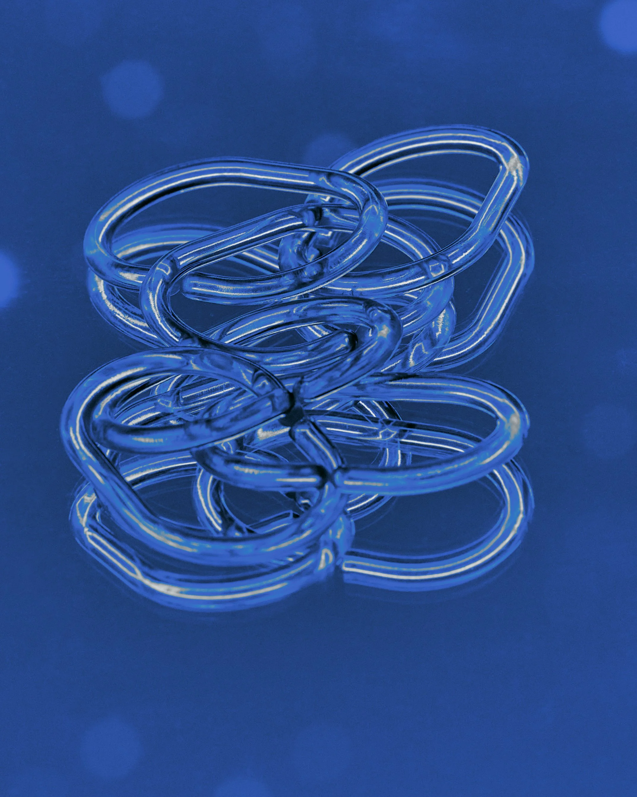 A pile of transparent blue rubber bands on a dark surface with blue bokeh lights in the background.