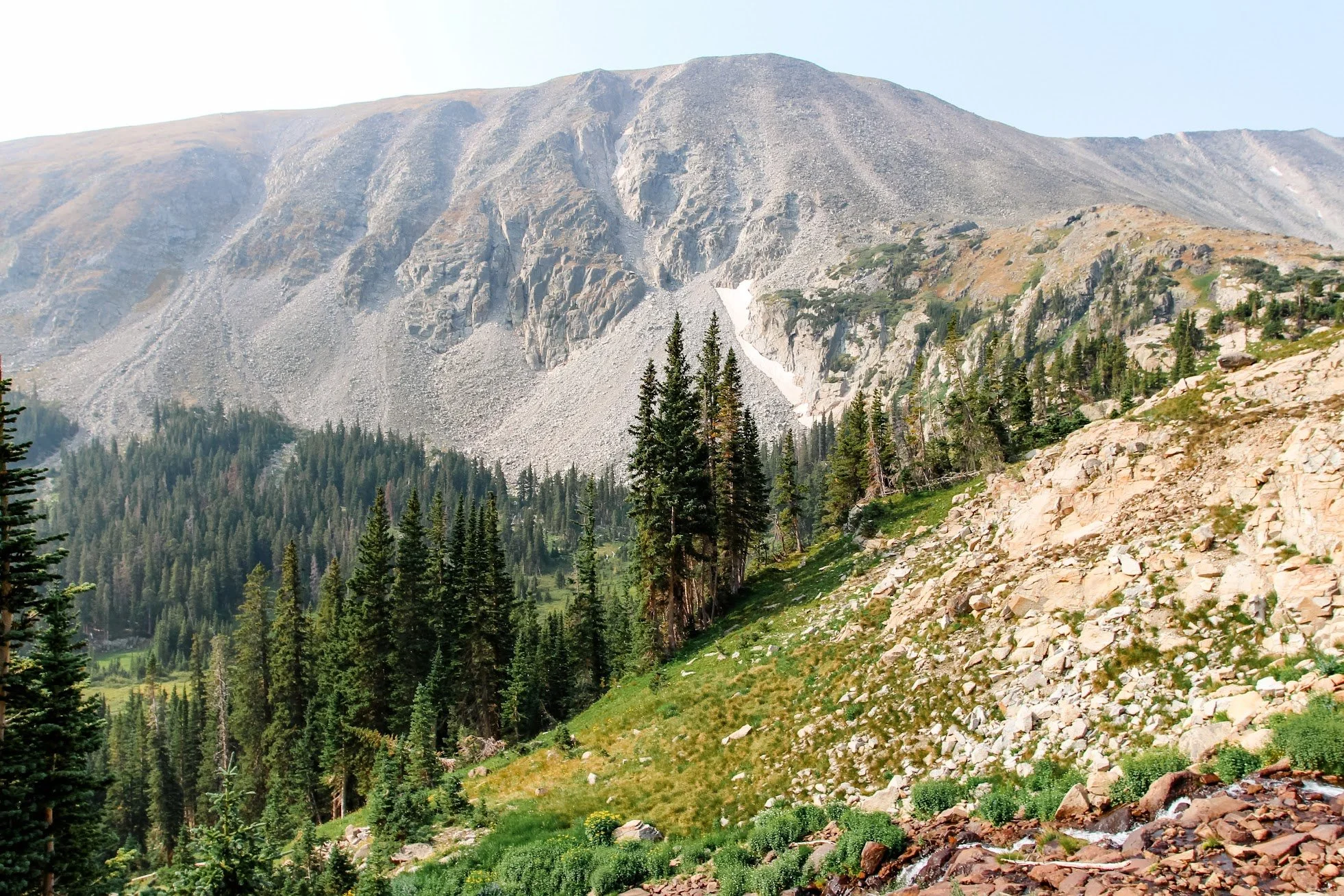 Four partiers pose with drinks in front of a DJ booth at Tropicana Day Club in Mykonos.
