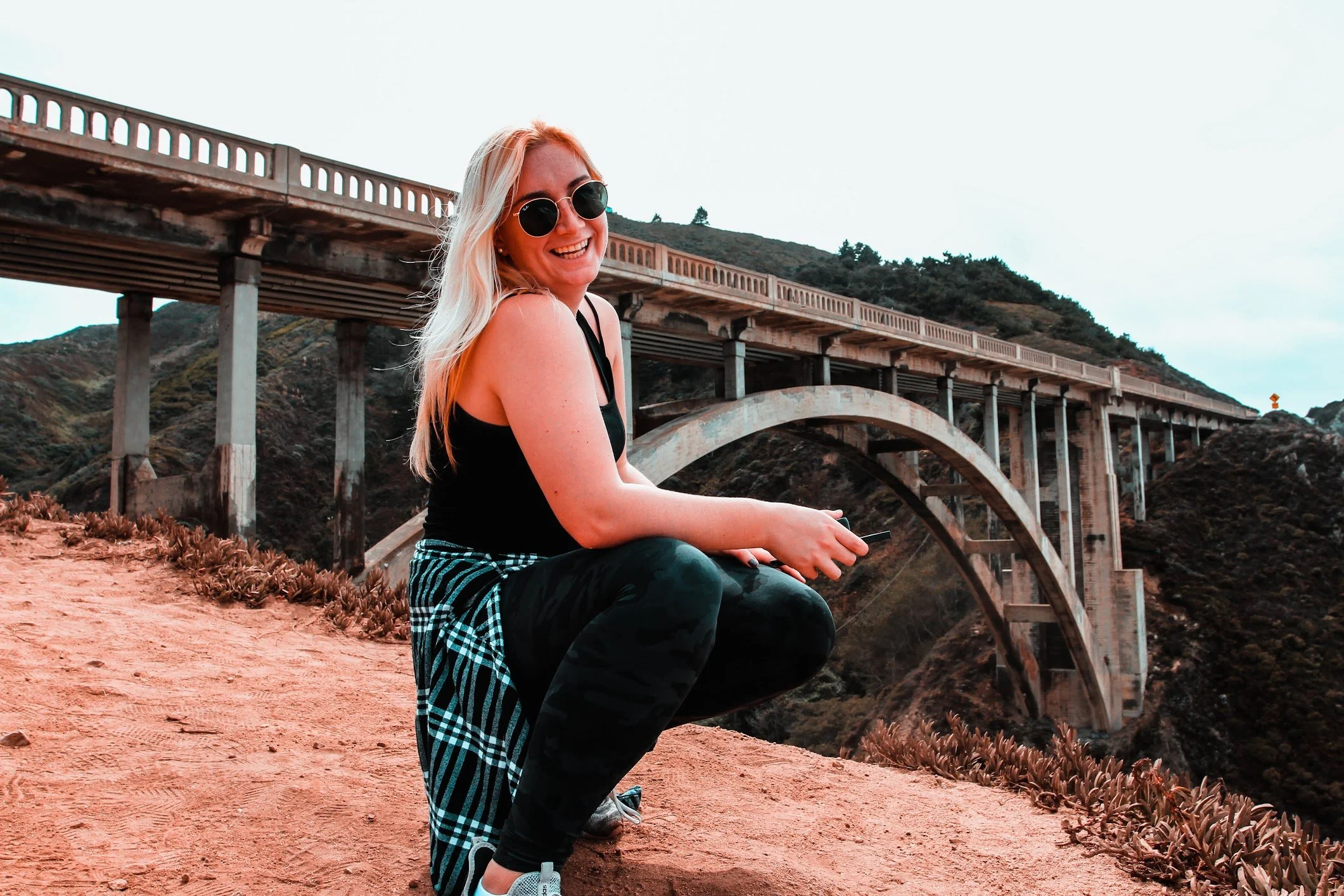 Four partiers pose with drinks in front of a DJ booth at Tropicana Day Club in Mykonos.