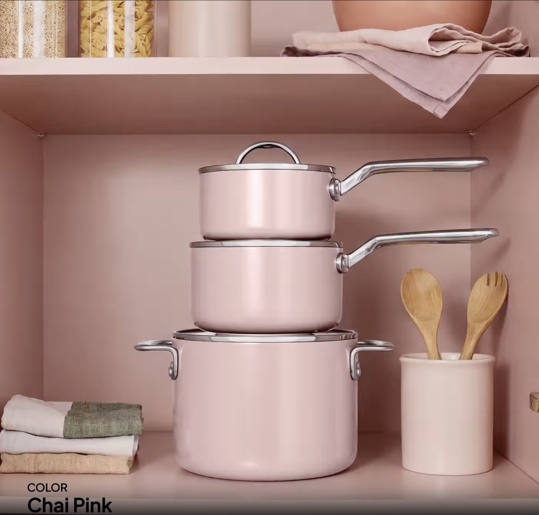 Ninja NeverQuit ceramic cookware in Chai Pink stacked neatly on a kitchen shelf.