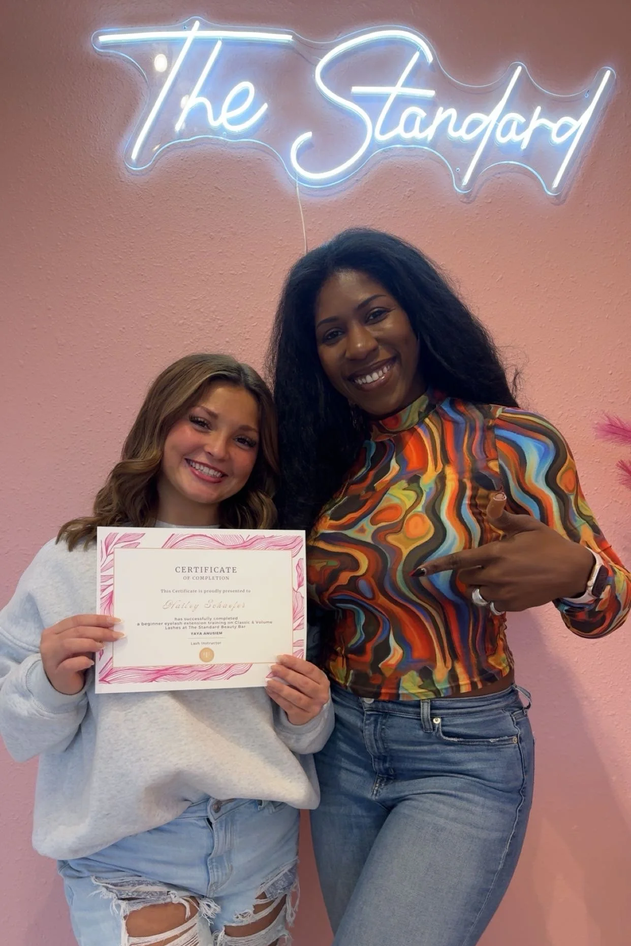 Yaya is smiling with her student that finished her program