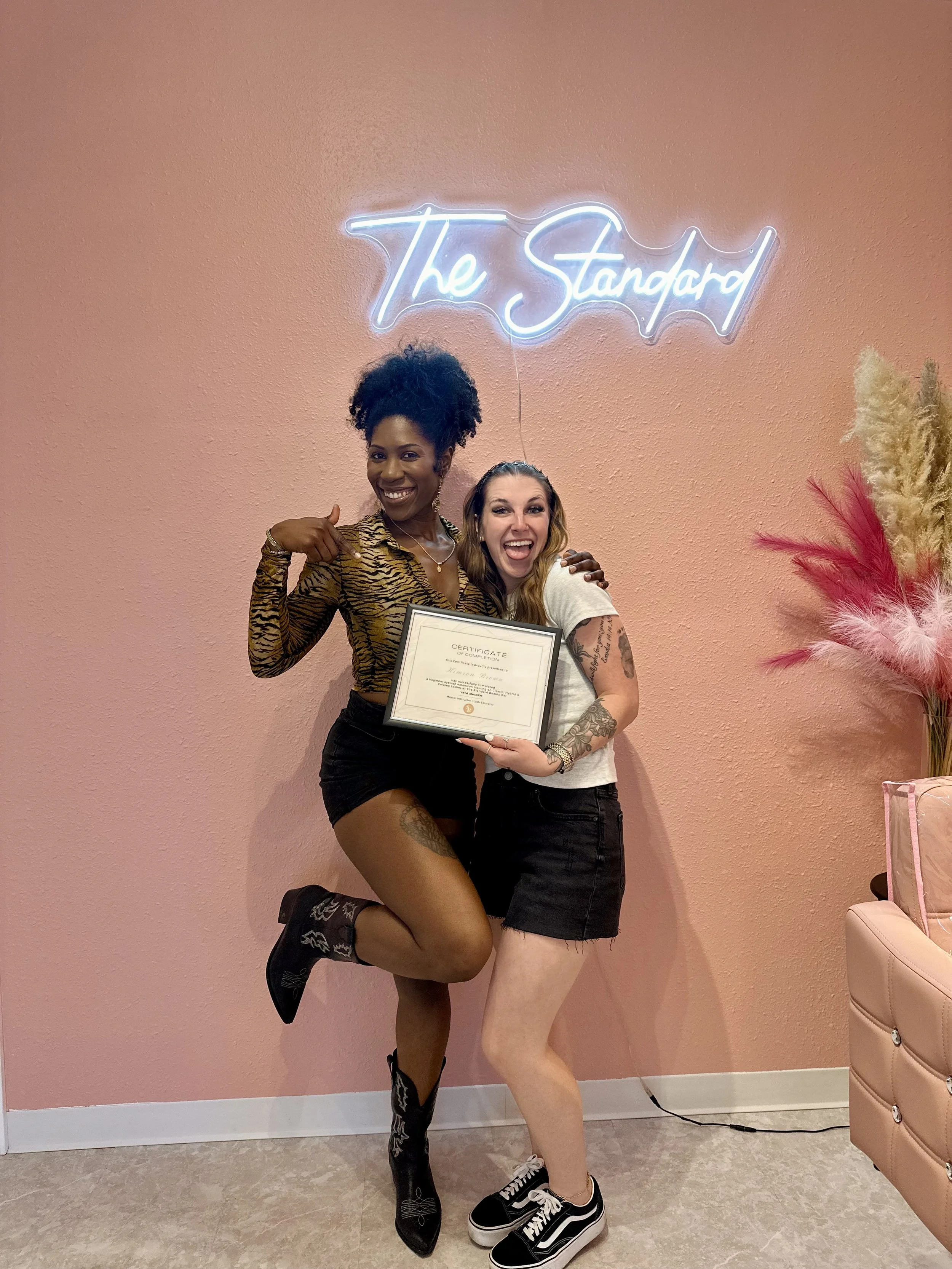 Yaya the teacher is standing with student holding certificate