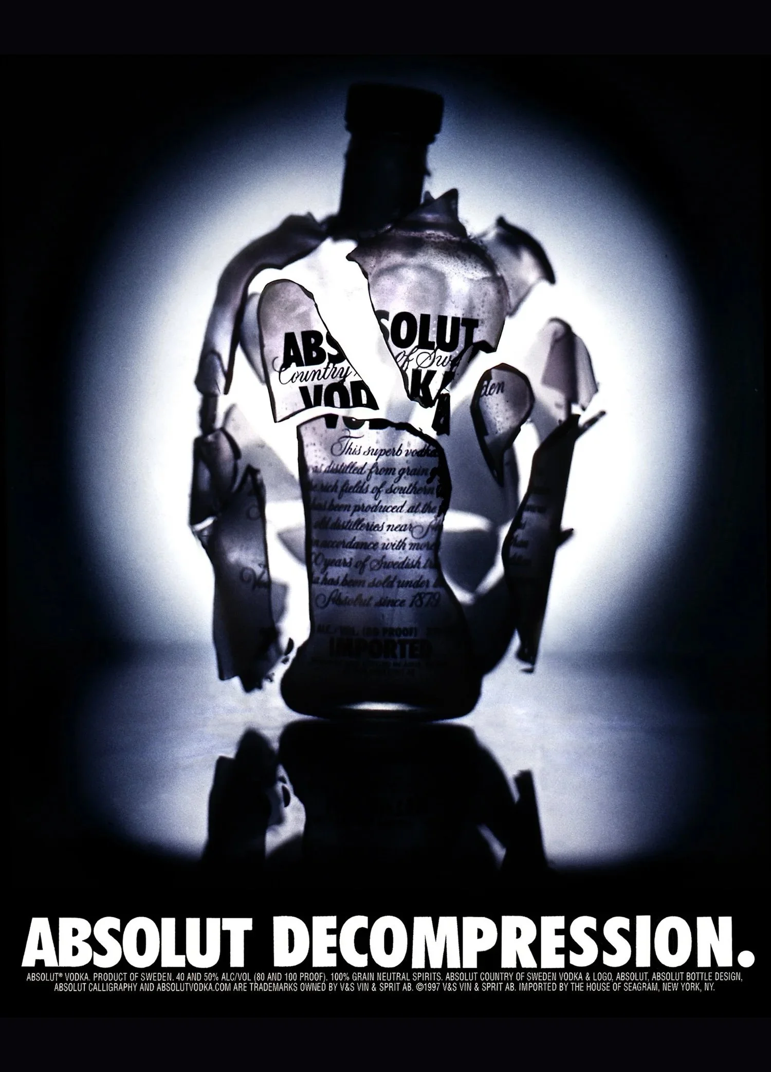 A black and white advertisement for Absolut Vodka featuring a broken glass bottle with distressed text and a bright halo behind it, with the words "ABSOLUT DECOMPRESSION" at the bottom.