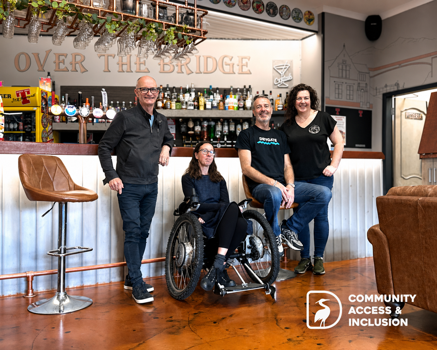 Image shows Gavin, Isabel, Louis and Joy in front of the bar in Over The Bridge as part of the donation presentation