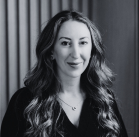 Black and white portrait of a person with long blonde hair sitting in a living room.