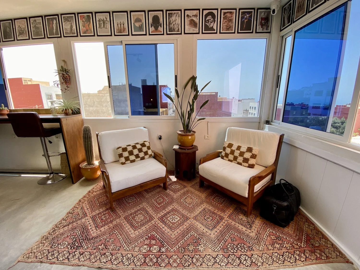 two chairs colourful rug and large windows, place to relax at coworking studio