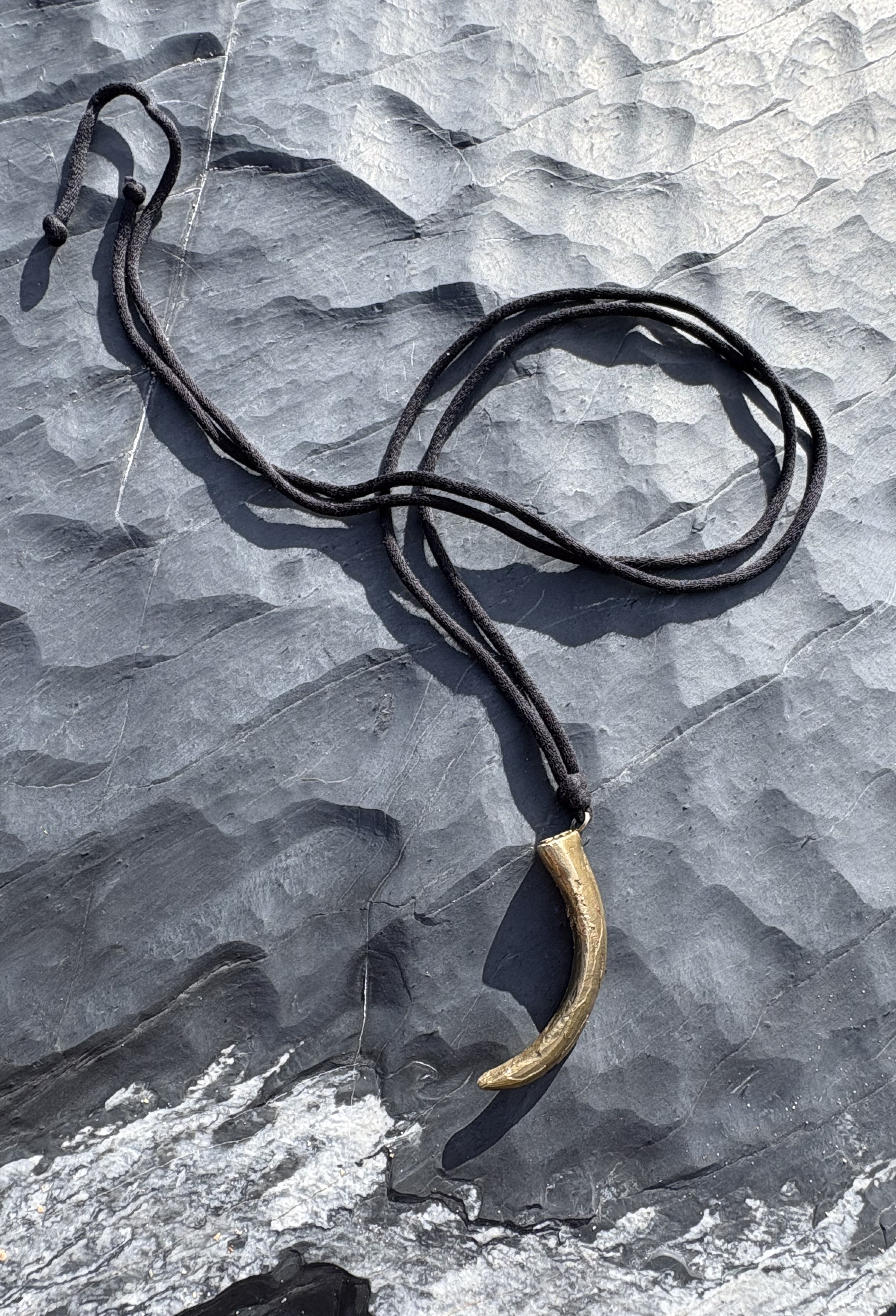 Gold tusk on black and white rock.png