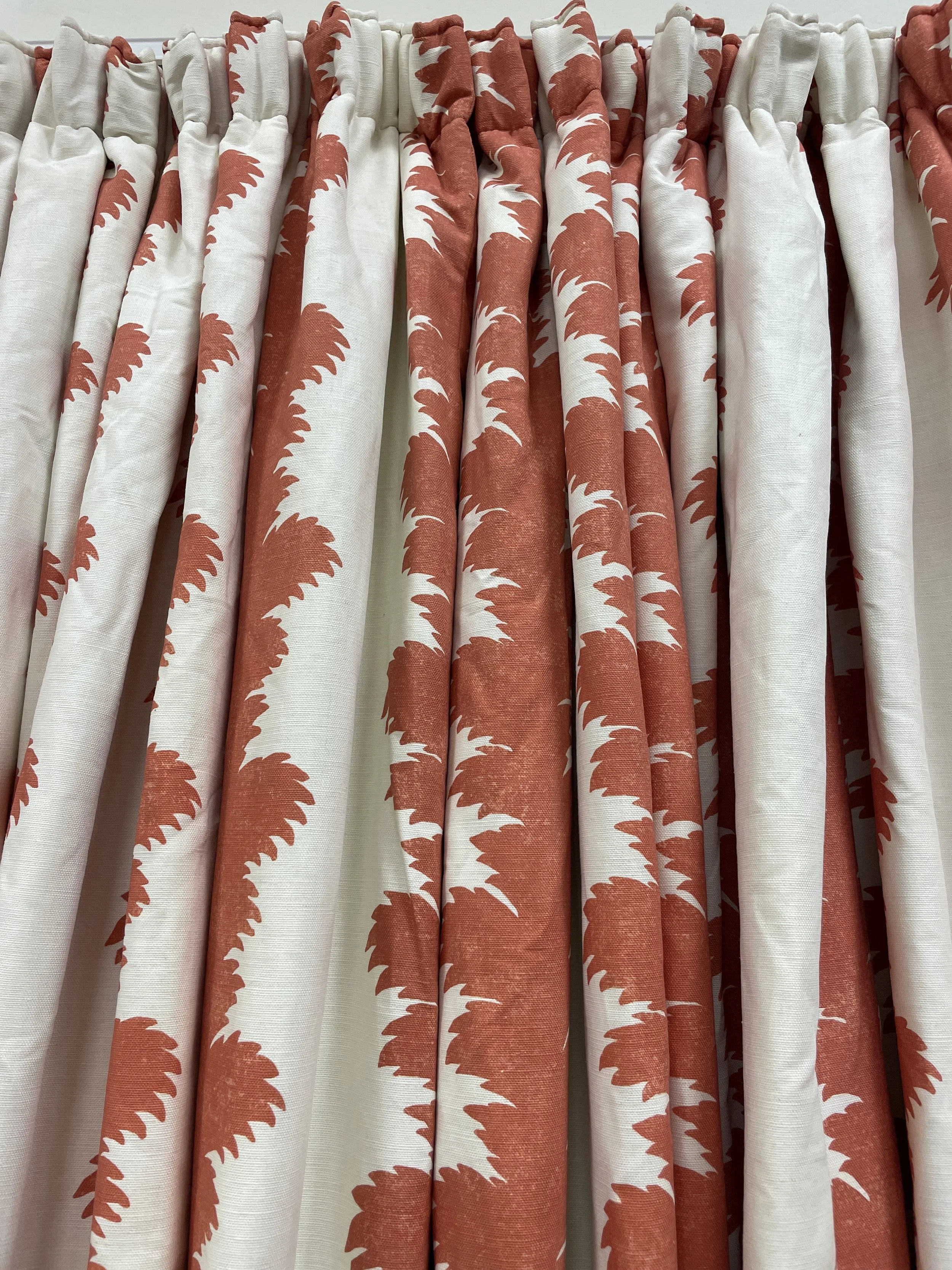 Red curtains with pleats and a decorative valance with ruffles and fringe.