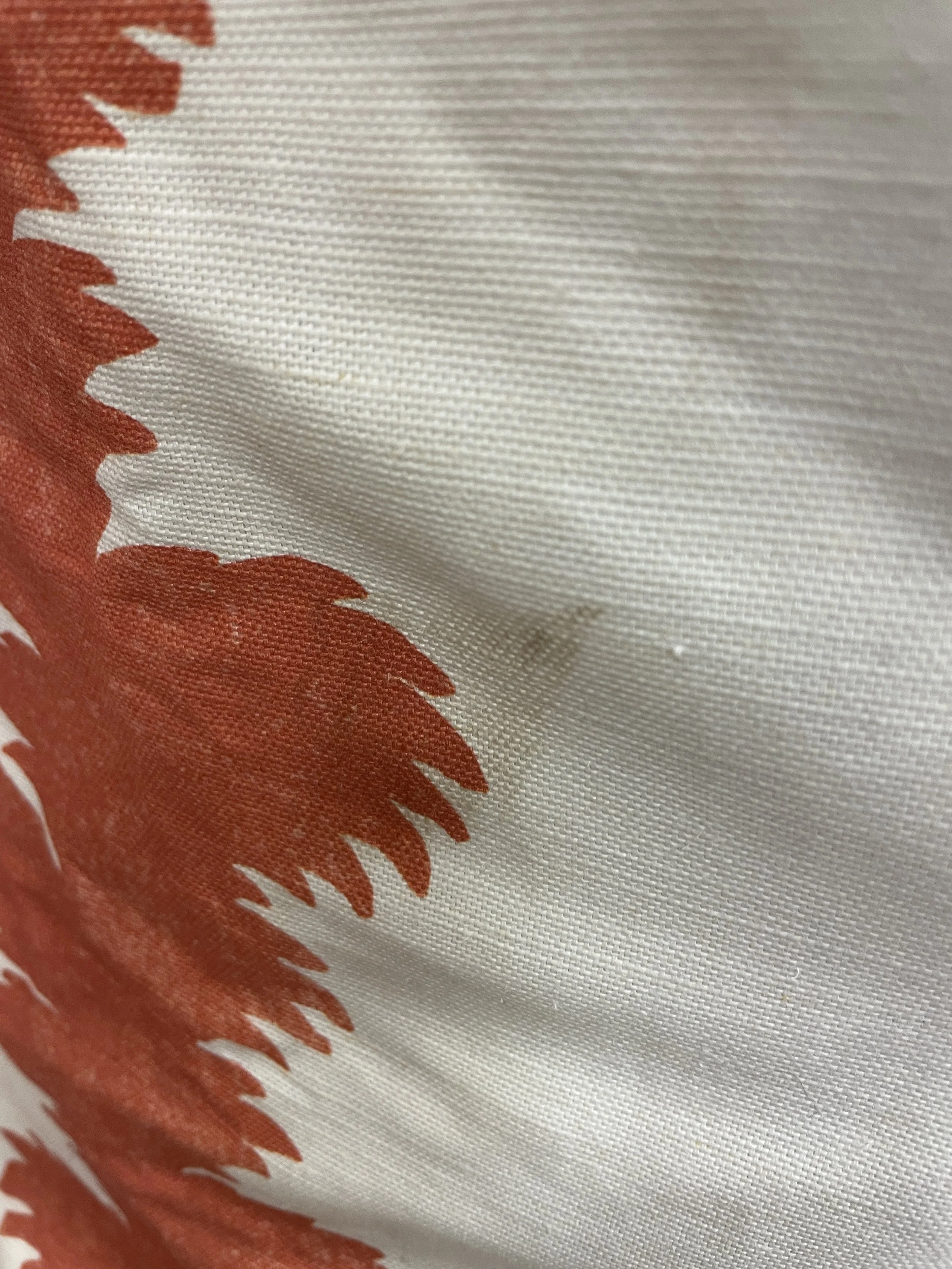 Close-up of a fabric with orange and white patterns, possibly a textile or clothing material.