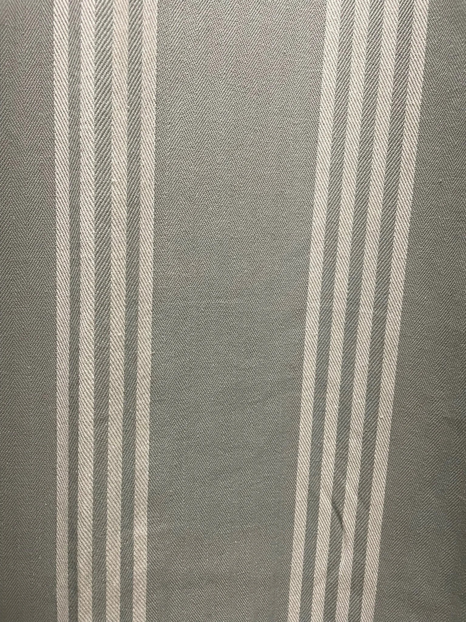 Close-up view of striped Blue grey curtain fabric with alternating light and dark grey vertical stripes.