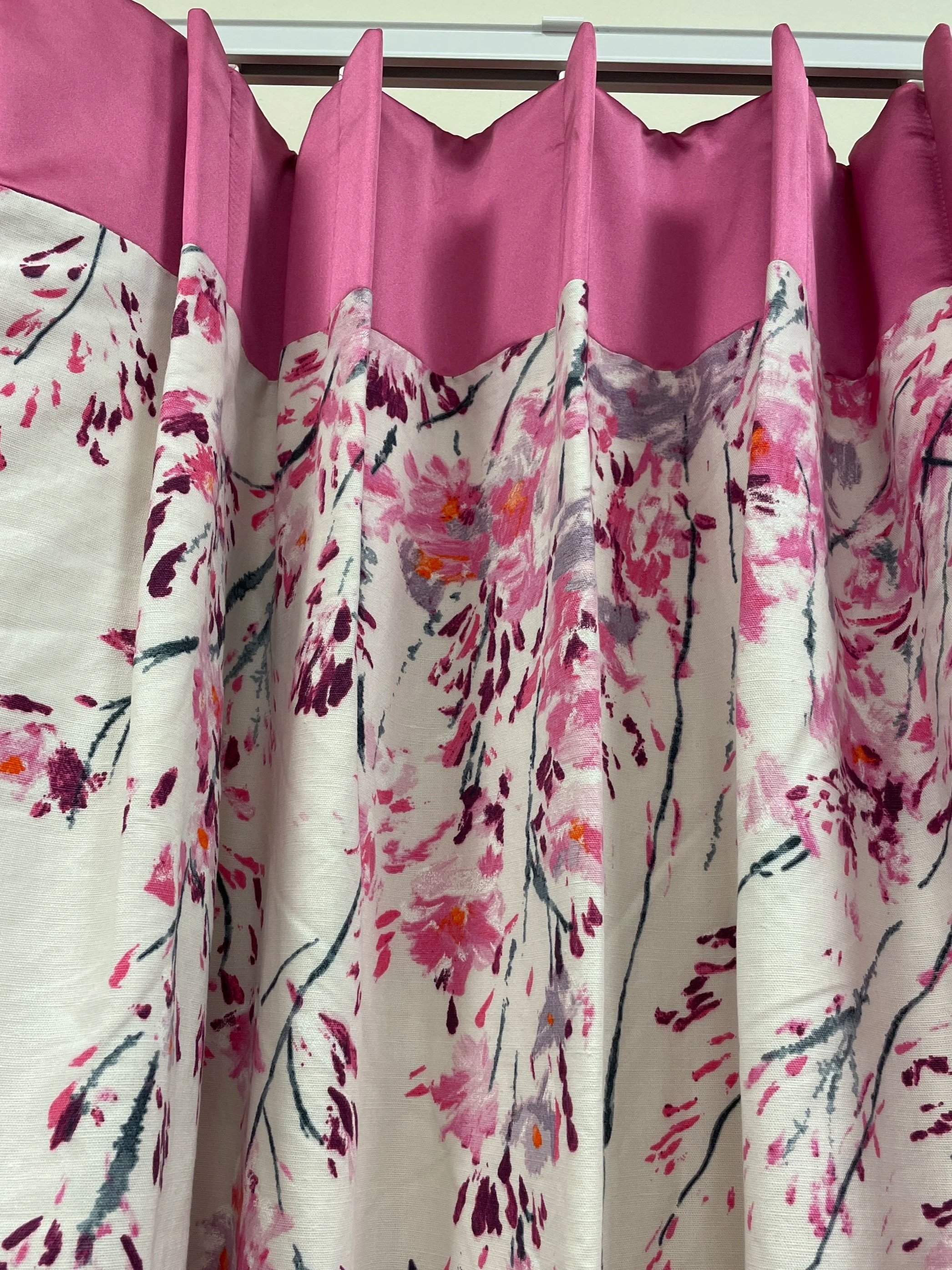 Colorful floral-patterned curtains with pink, orange, and purple flowers on a white background.