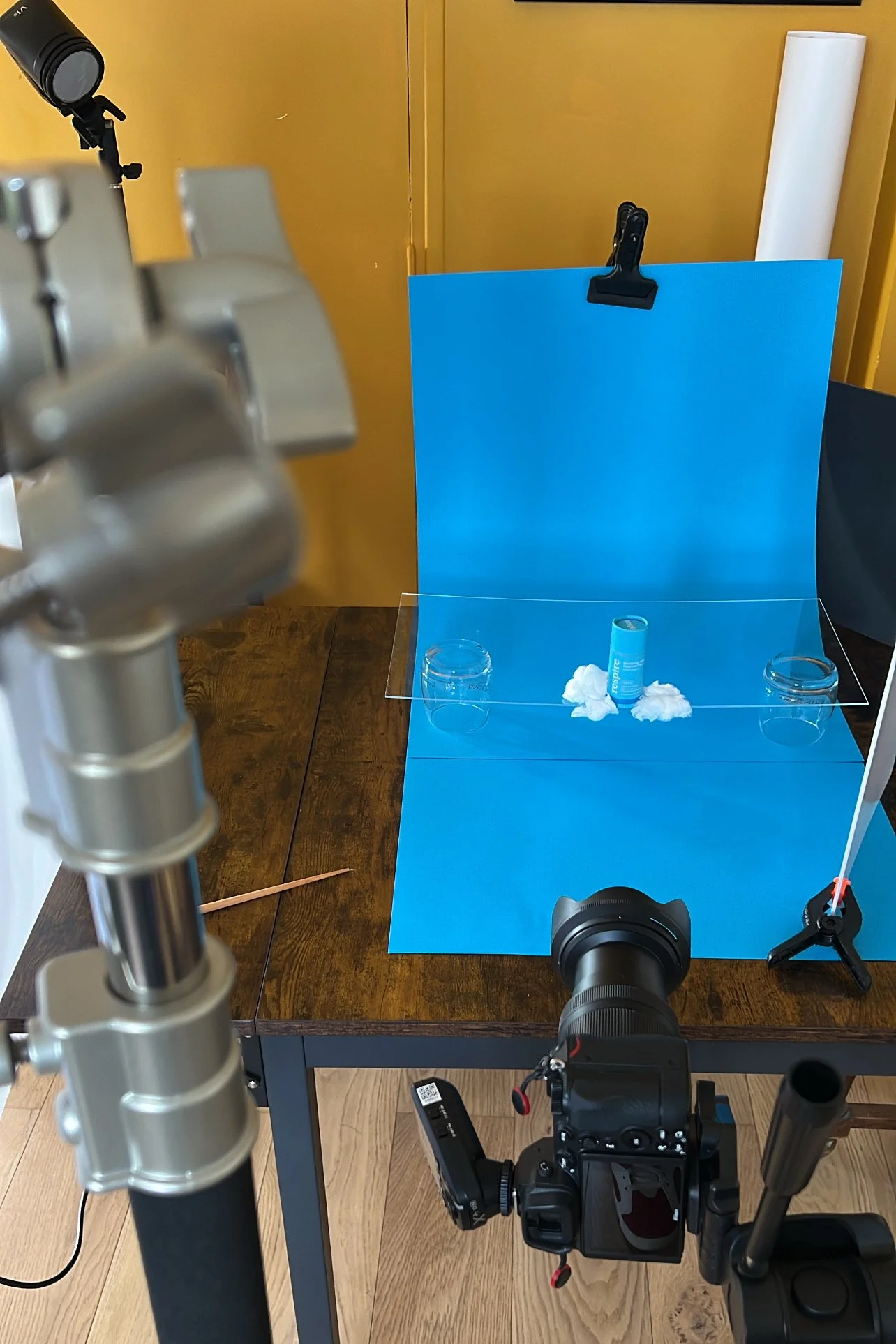 Behind the scenes : mise en scène produit avec appareil photo et fond bleu.