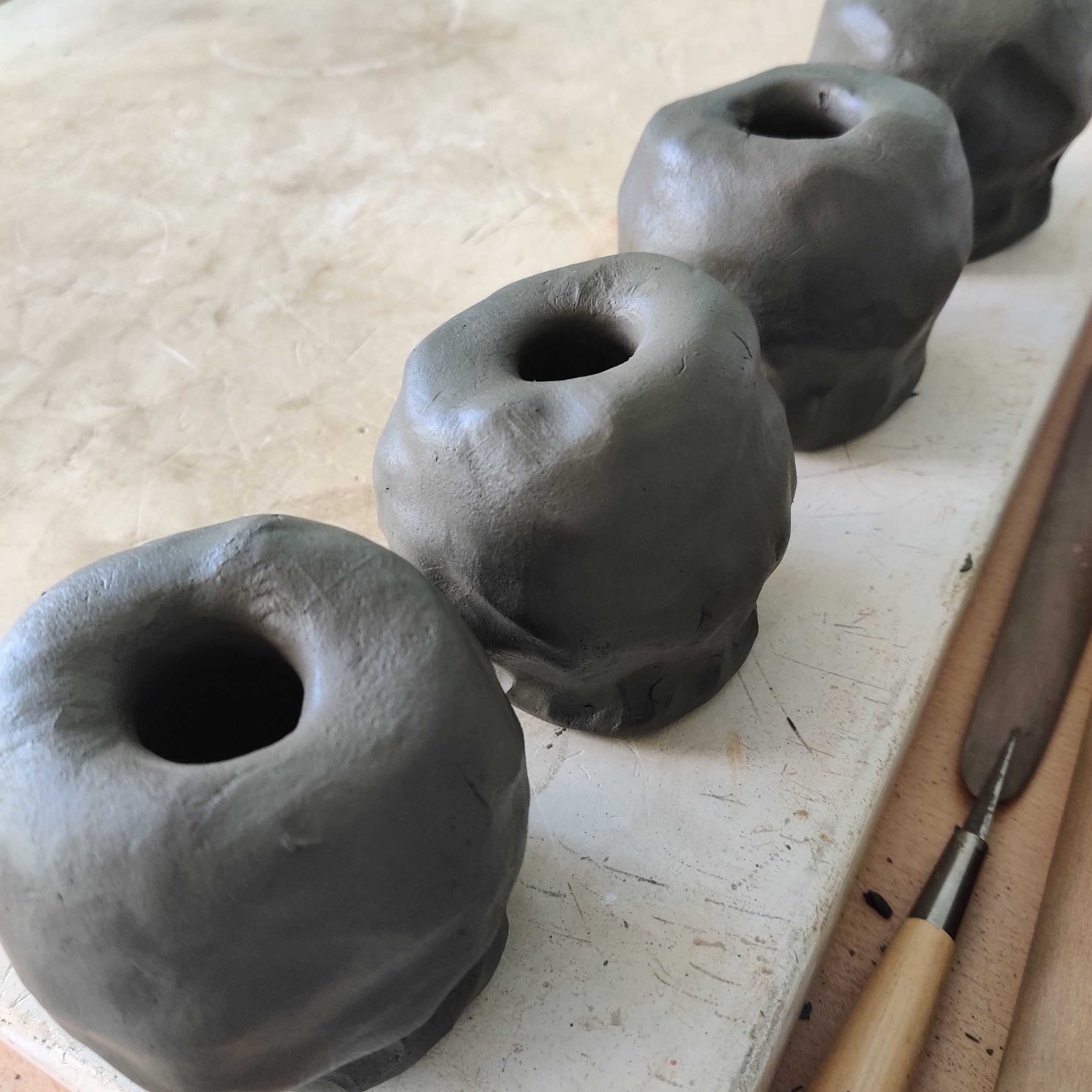 Four cups pinched from dark grogged clay 