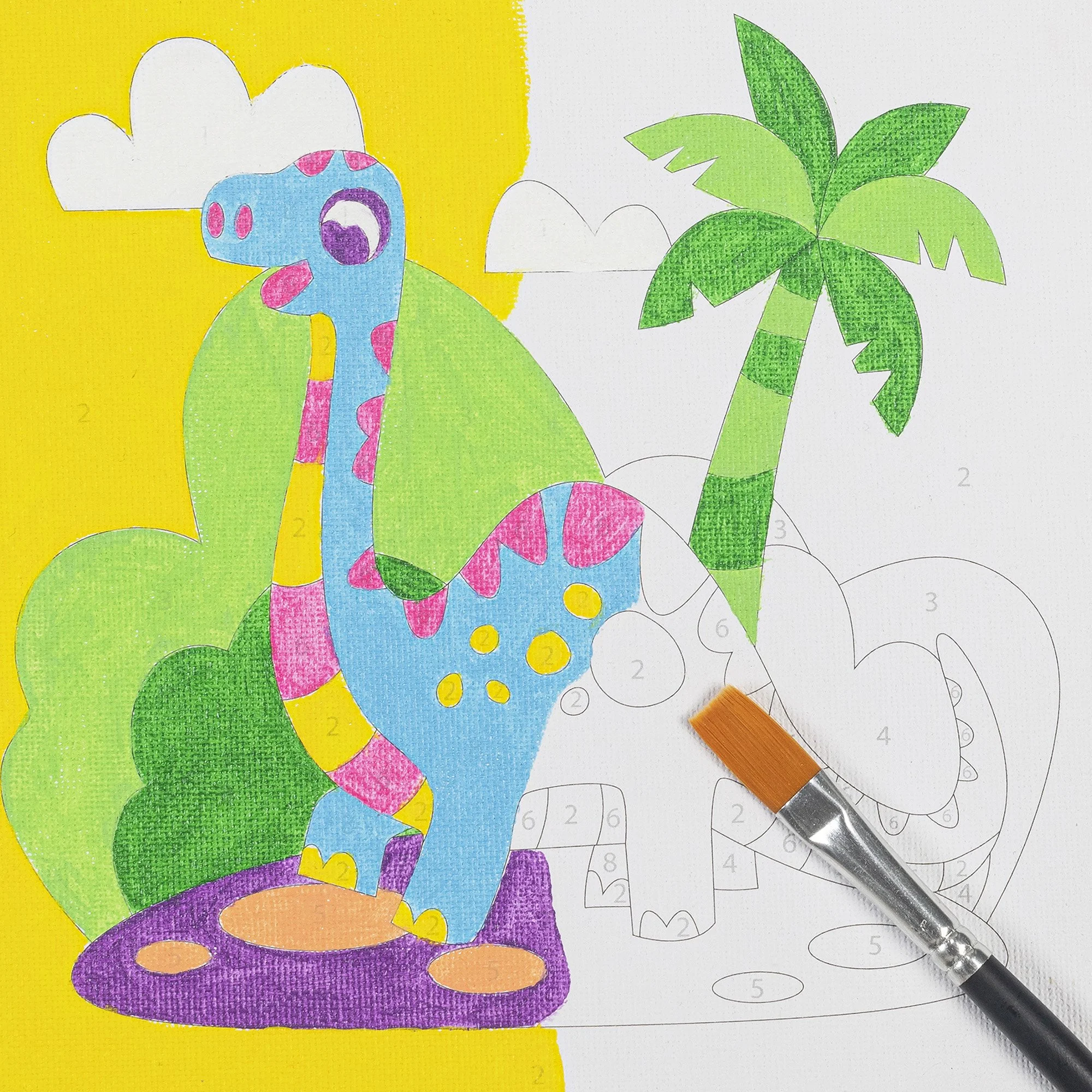 Colorful paint-by-numbers drawing of a cartoon giraffe standing next to a palm tree with a partially completed background, and a paintbrush resting on the paper.