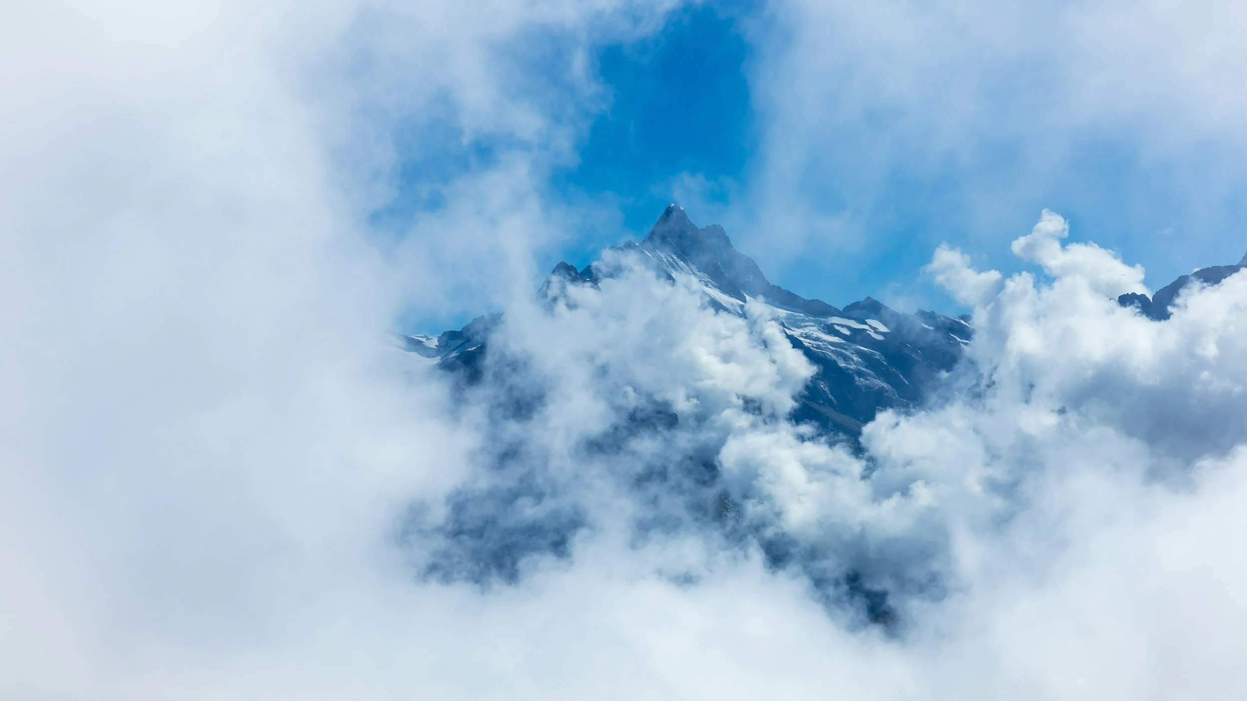Snow-capped mountain peak surrounded by clouds