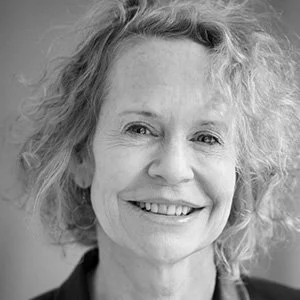 Portrait of a smiling woman with curly hair in black and white.