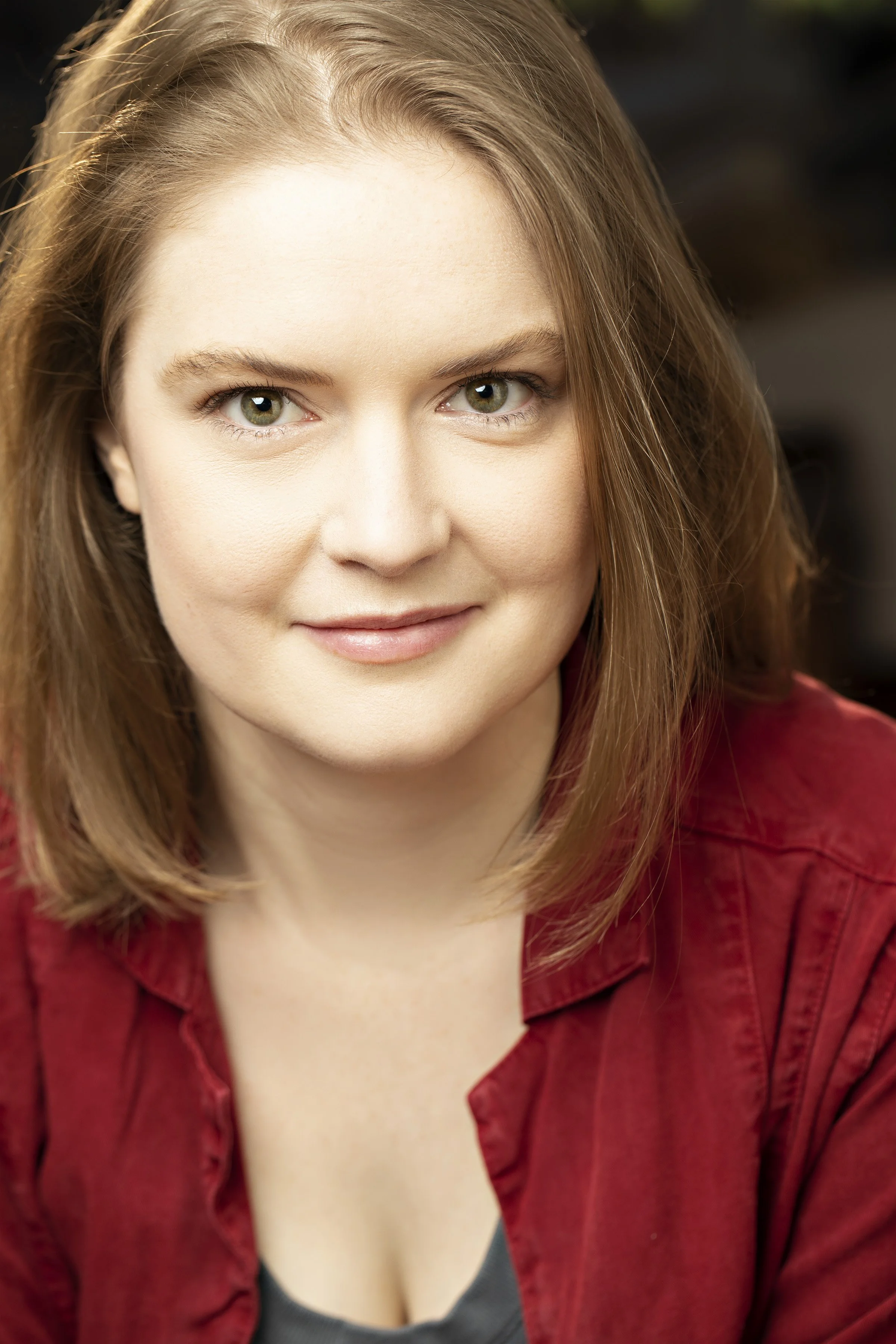 Portrait of a woman with short blonde hair wearing a red shirt.