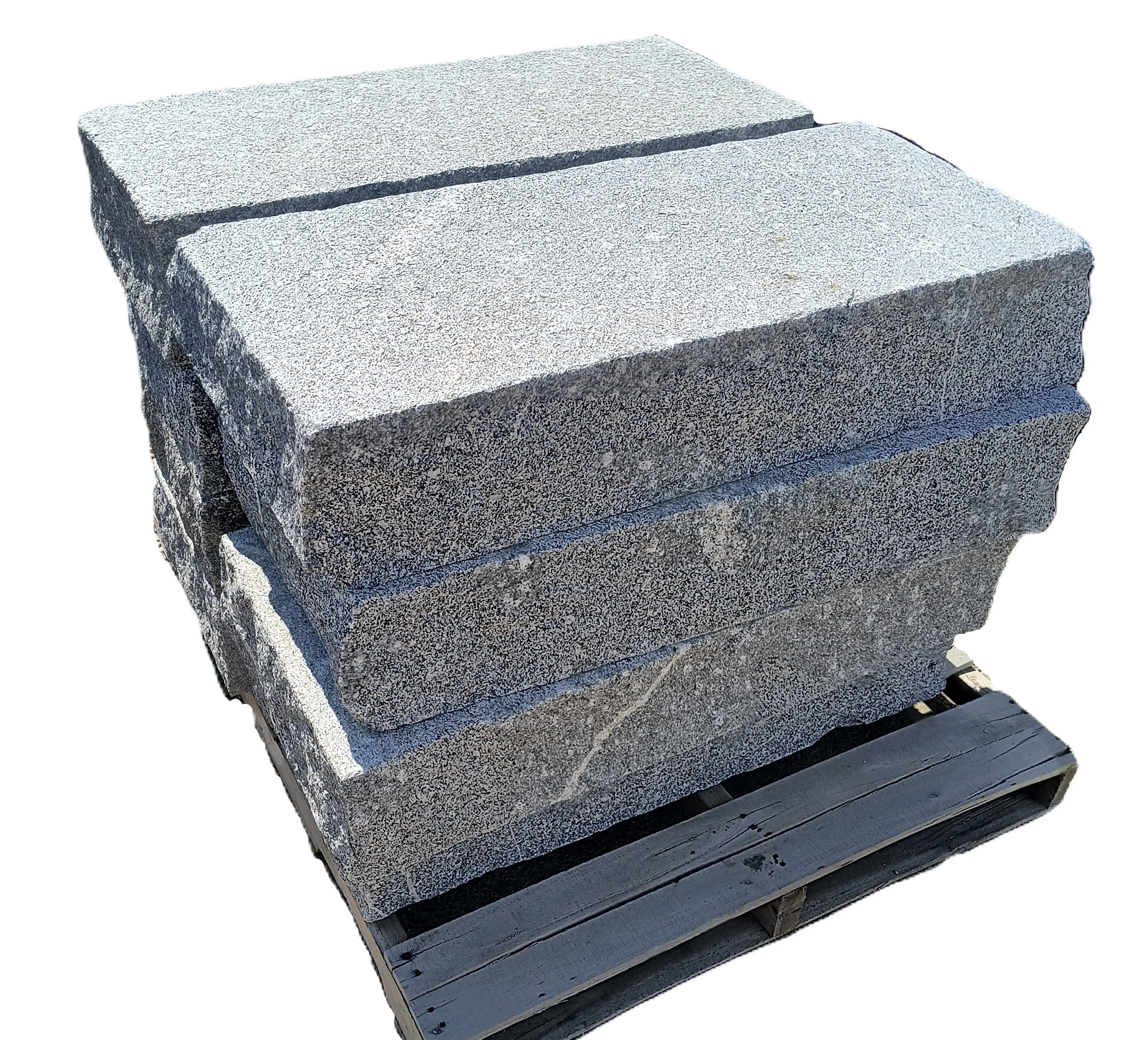 Stacks of large, flat stones arranged in two separate piles on wooden pallets outdoors on a dirt surface.