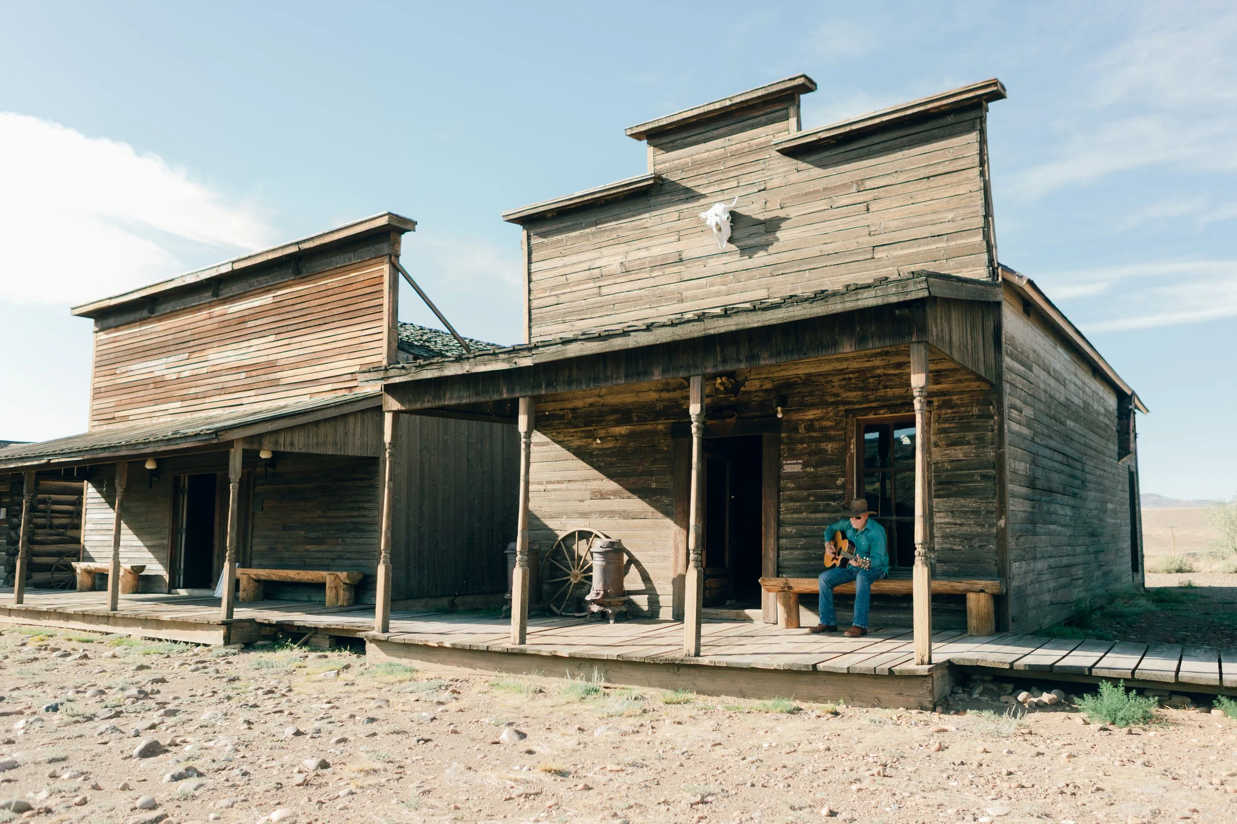 Wyoming musician Aaron Walker playing acoustic guitar on the boardwalk at Old Trail Town in Cody, Wyoming.