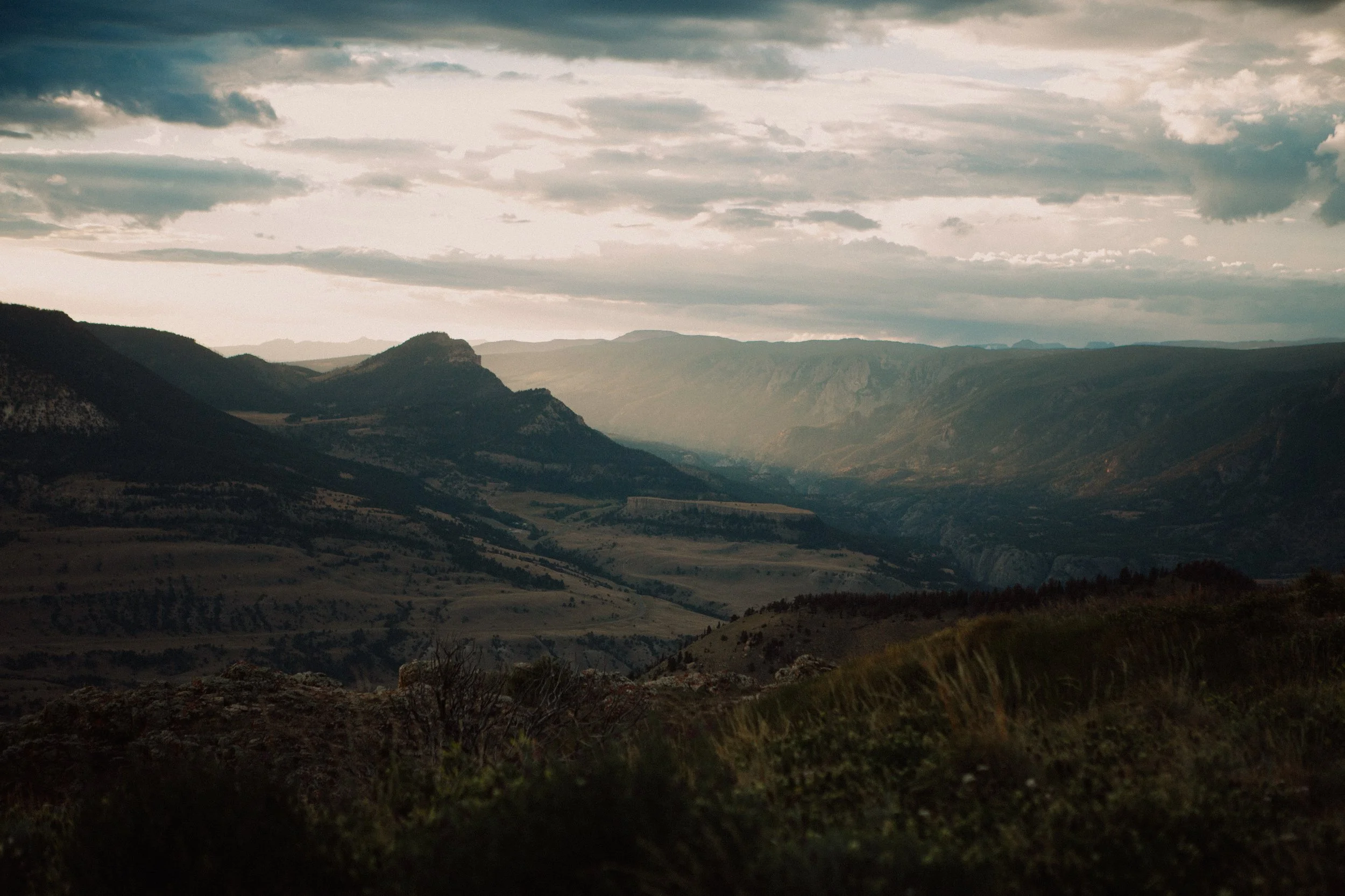 Expansive mountain valley landscape near Beartooth Highway with soft light coming through layered ridge lines