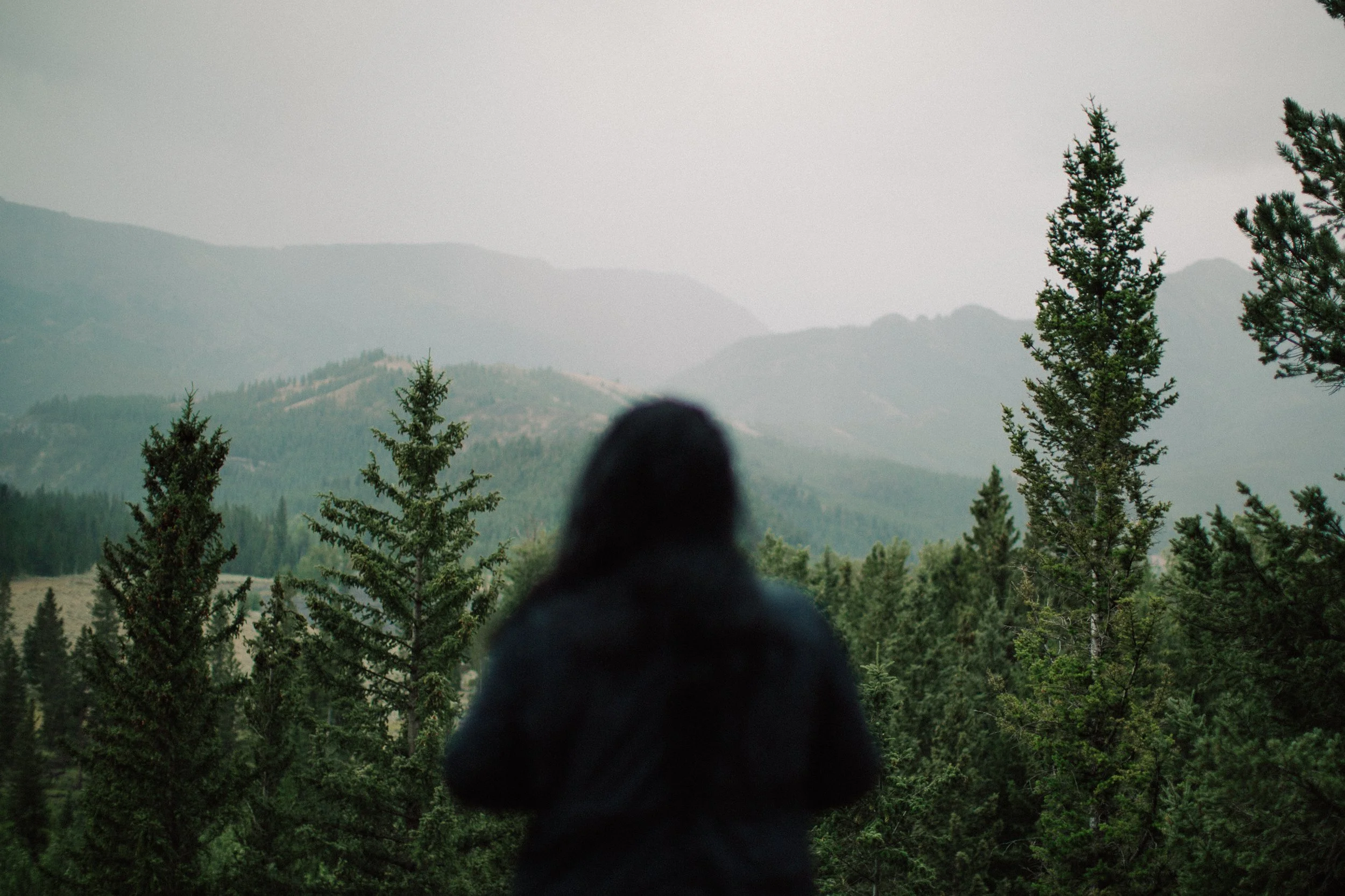 Woman standing in Wyoming mountain on a stormy evening