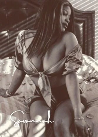 A woman sitting on a bed looking down at her shoulder with the name 'savannah' in the bottom left  corner 