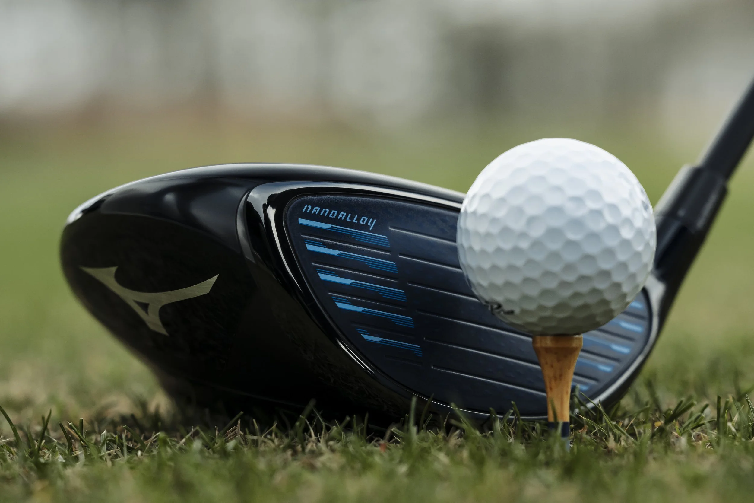 Golf club and golf ball on grass