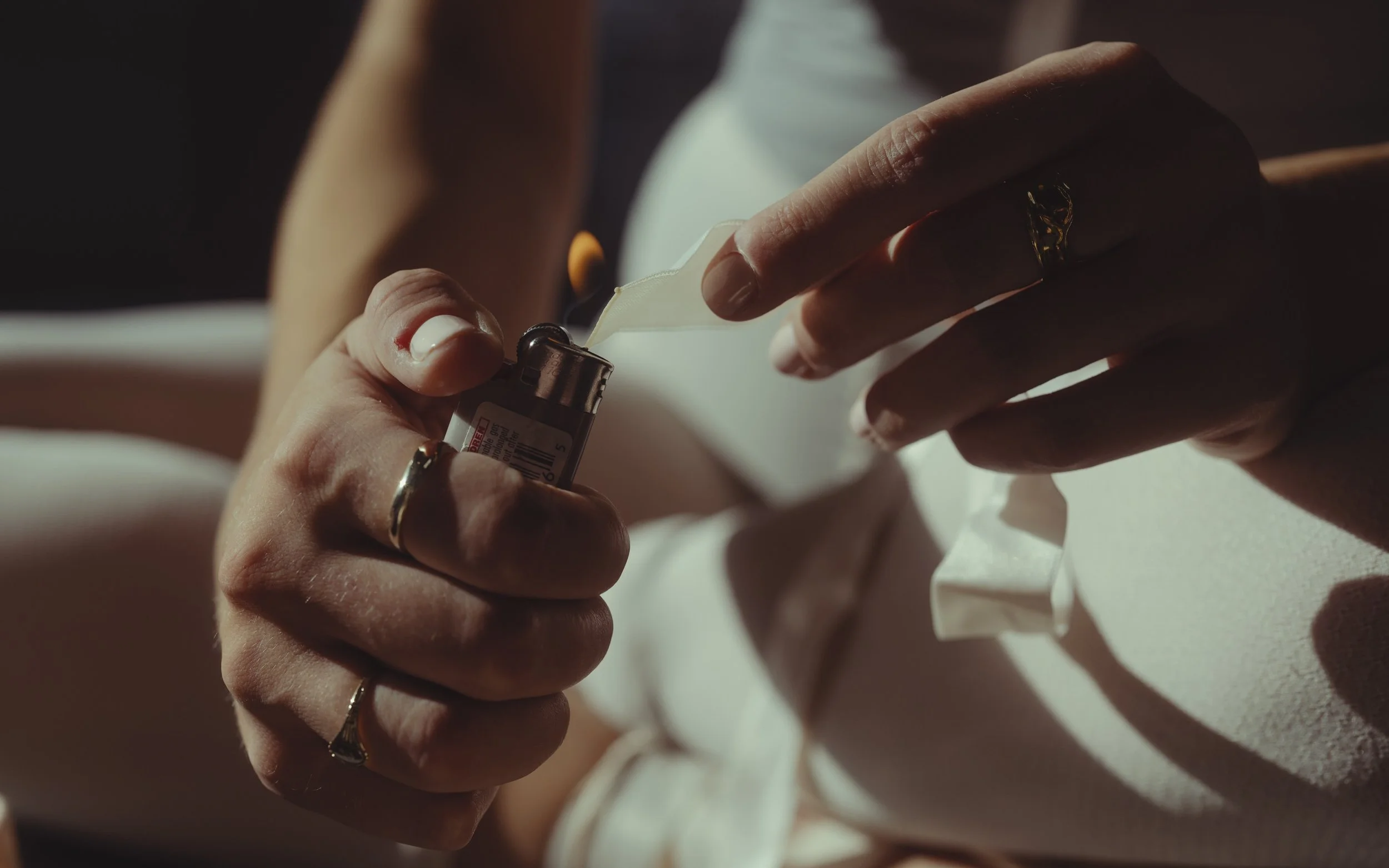A person's hands holding a small vial and a nasal spray bottle, preparing to use a nasal spray.