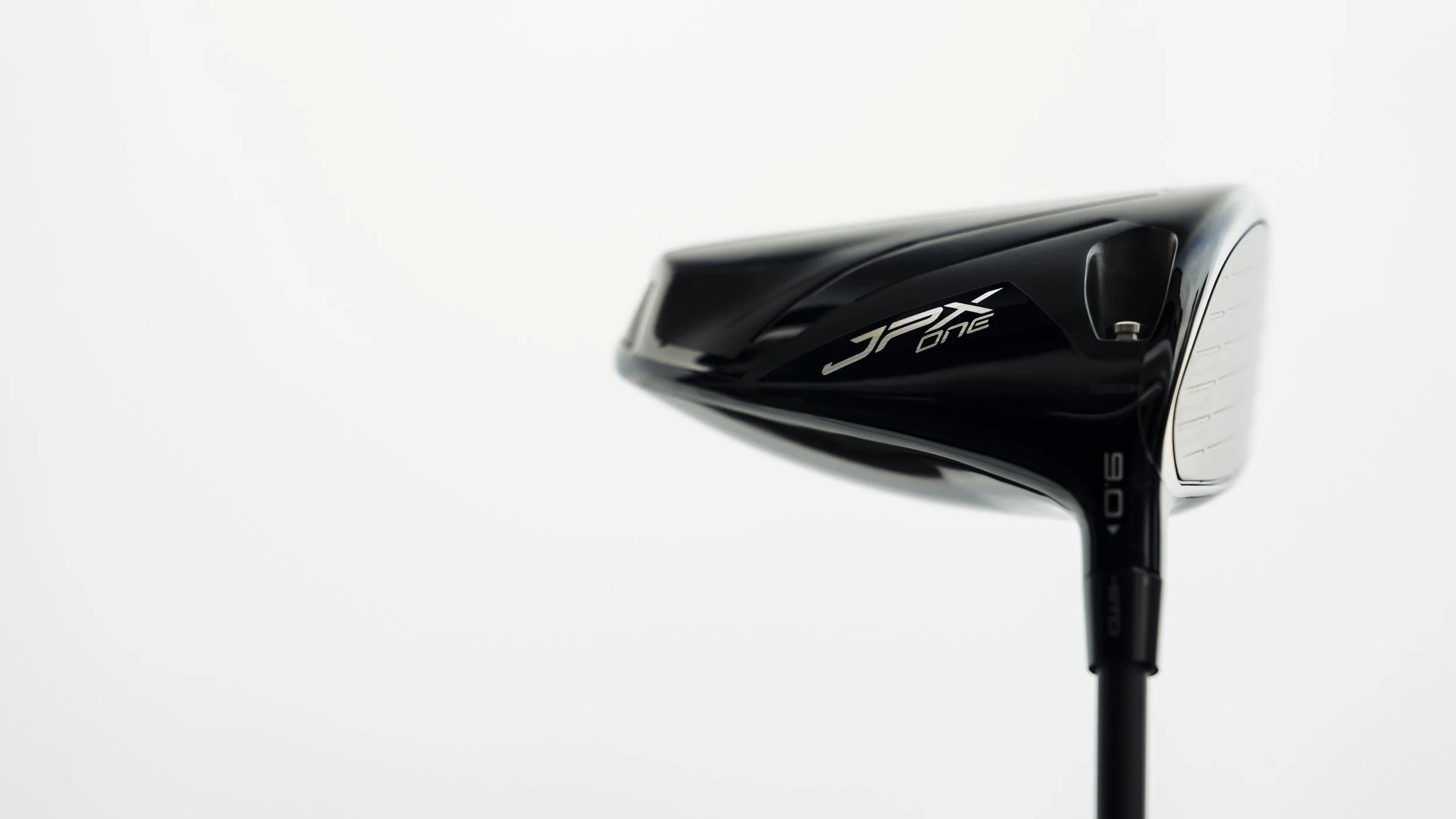 Close-up of a black golf club, specifically a Callaway Jax Knock hybrid, with a white background.