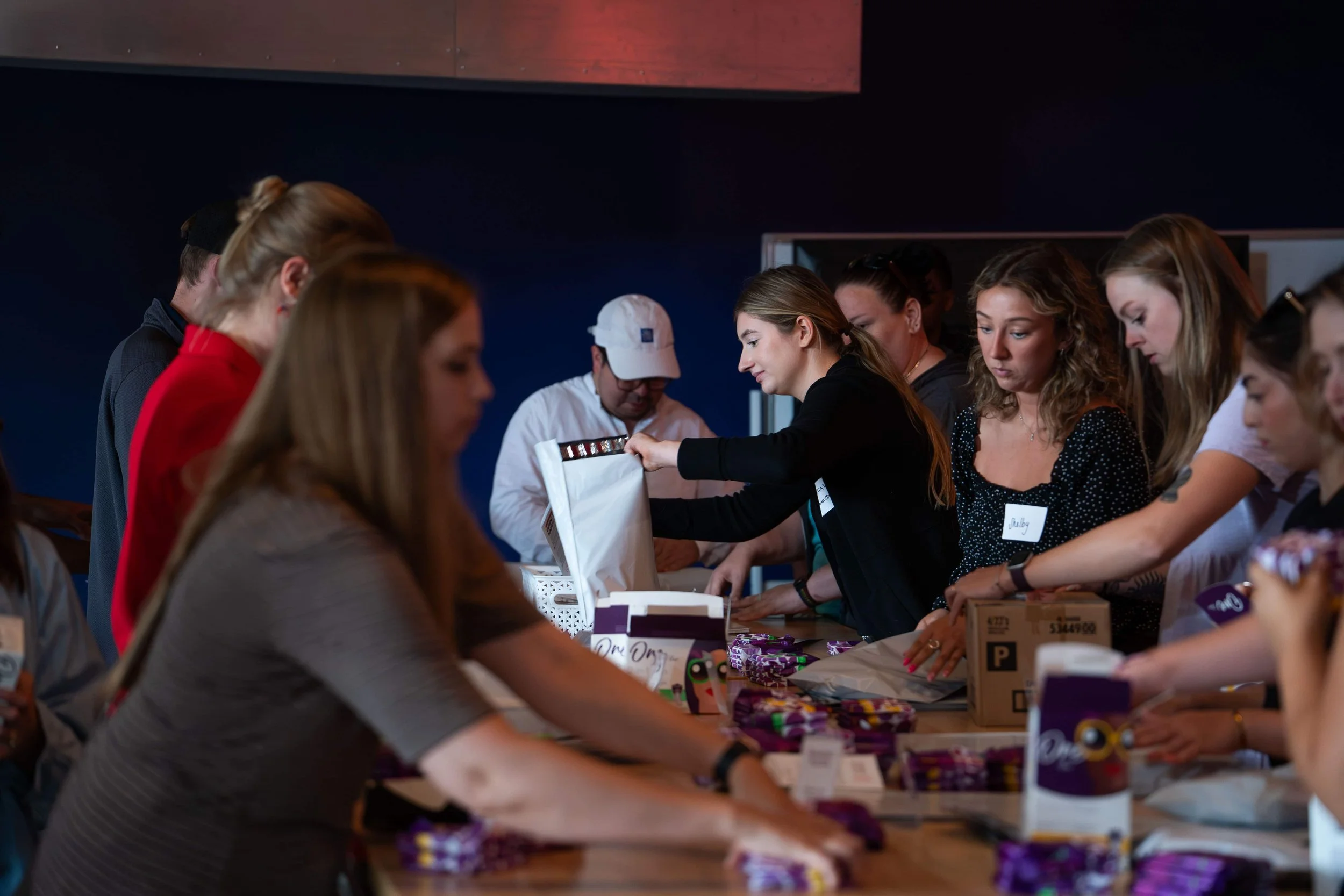 People gathered at a table packing period supplies.