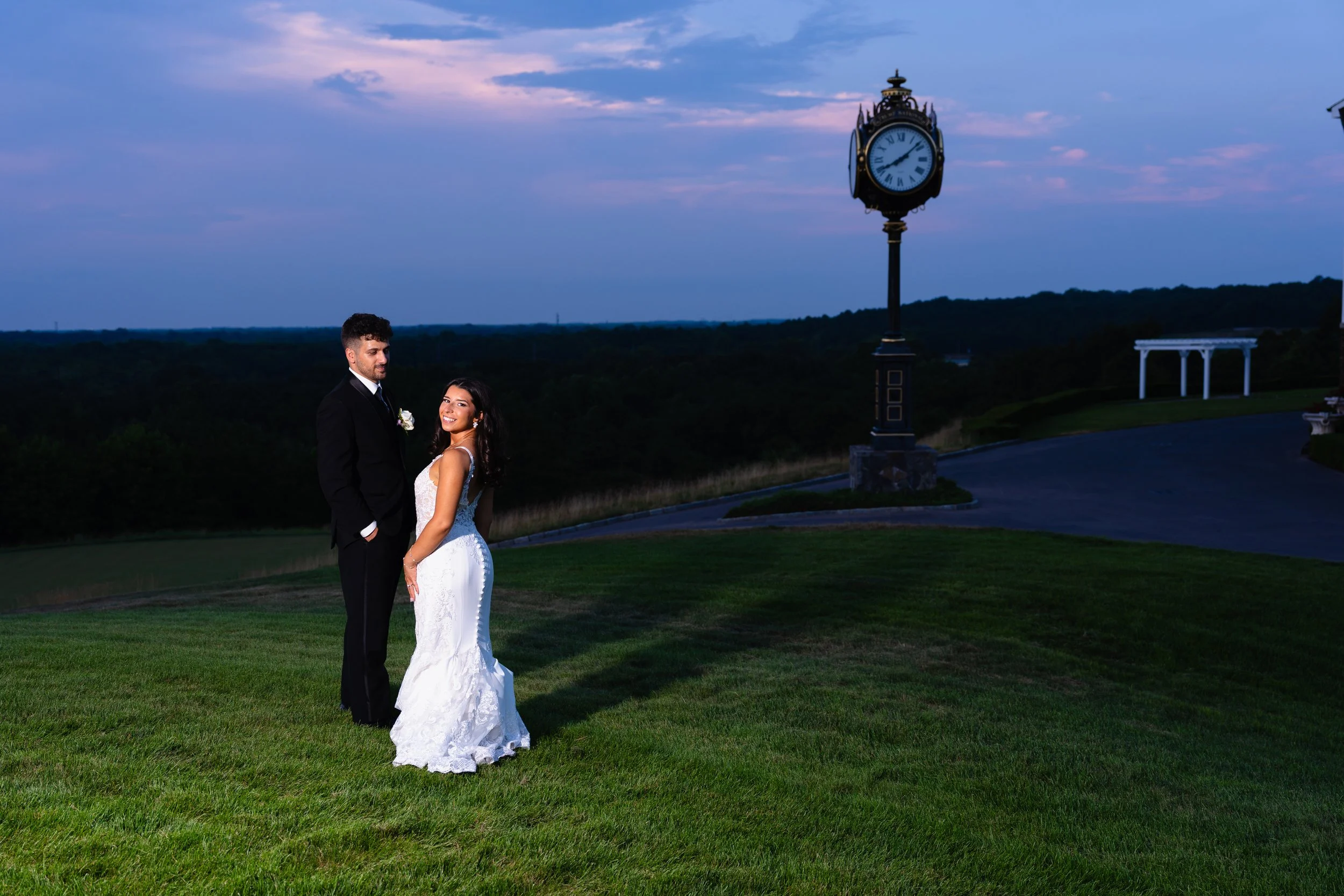 Bride and Groom embrace looking back at camera at sunset overlooking Trump National Gulf Course.