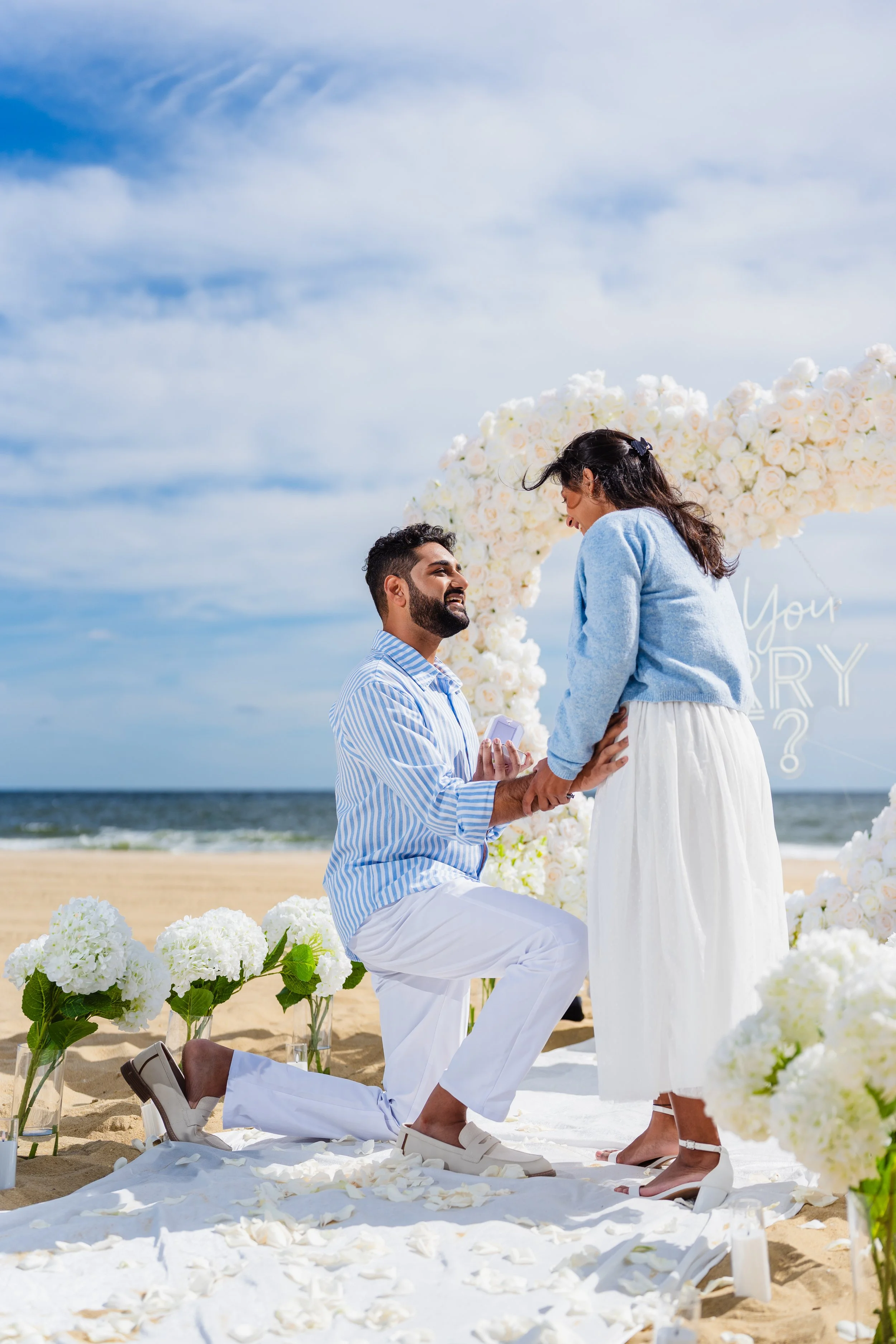 Man Down on one knee for a proposal on the beach in Long Branch, New Jersey