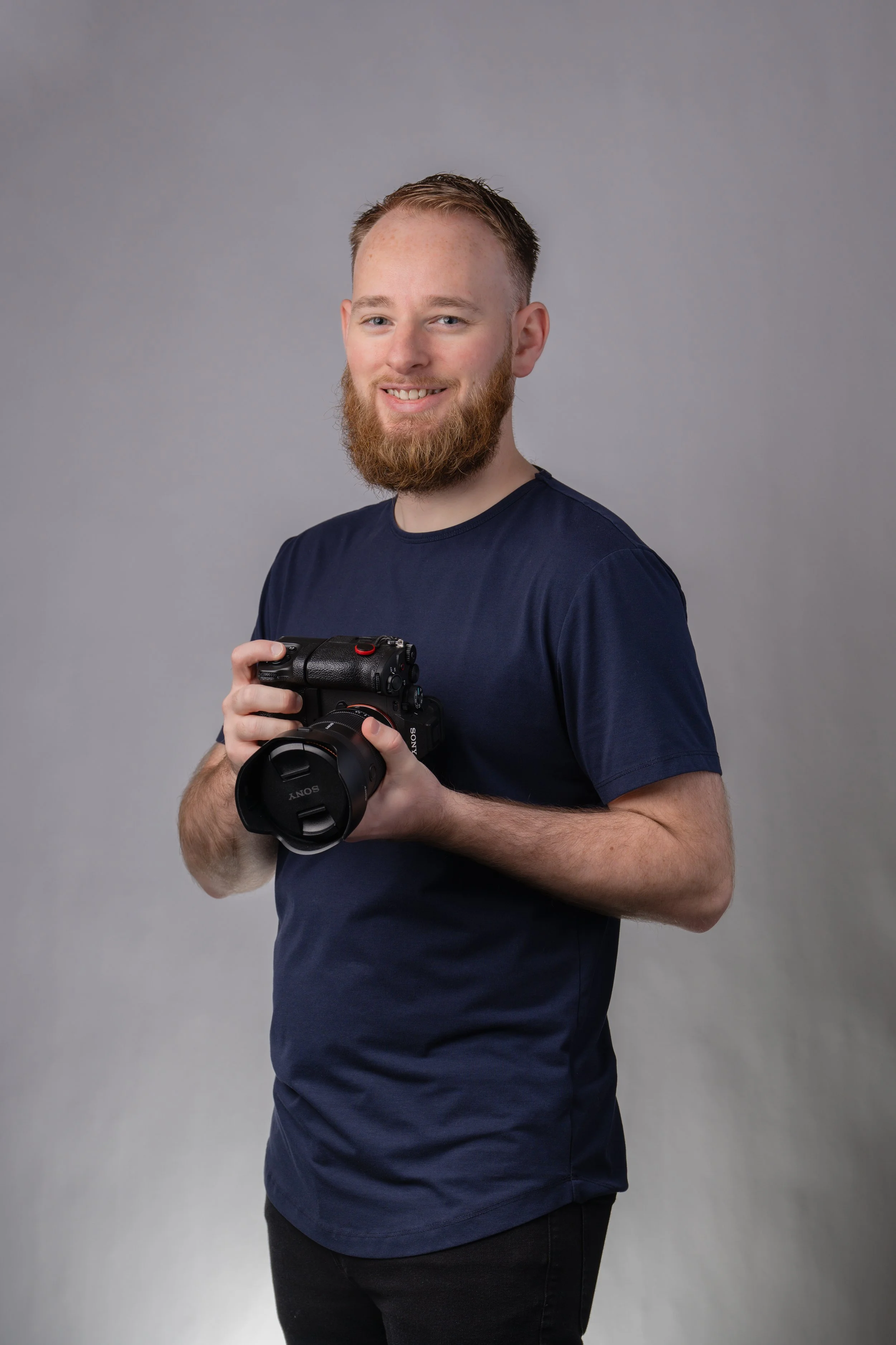 Steve Magee posed holding a camera