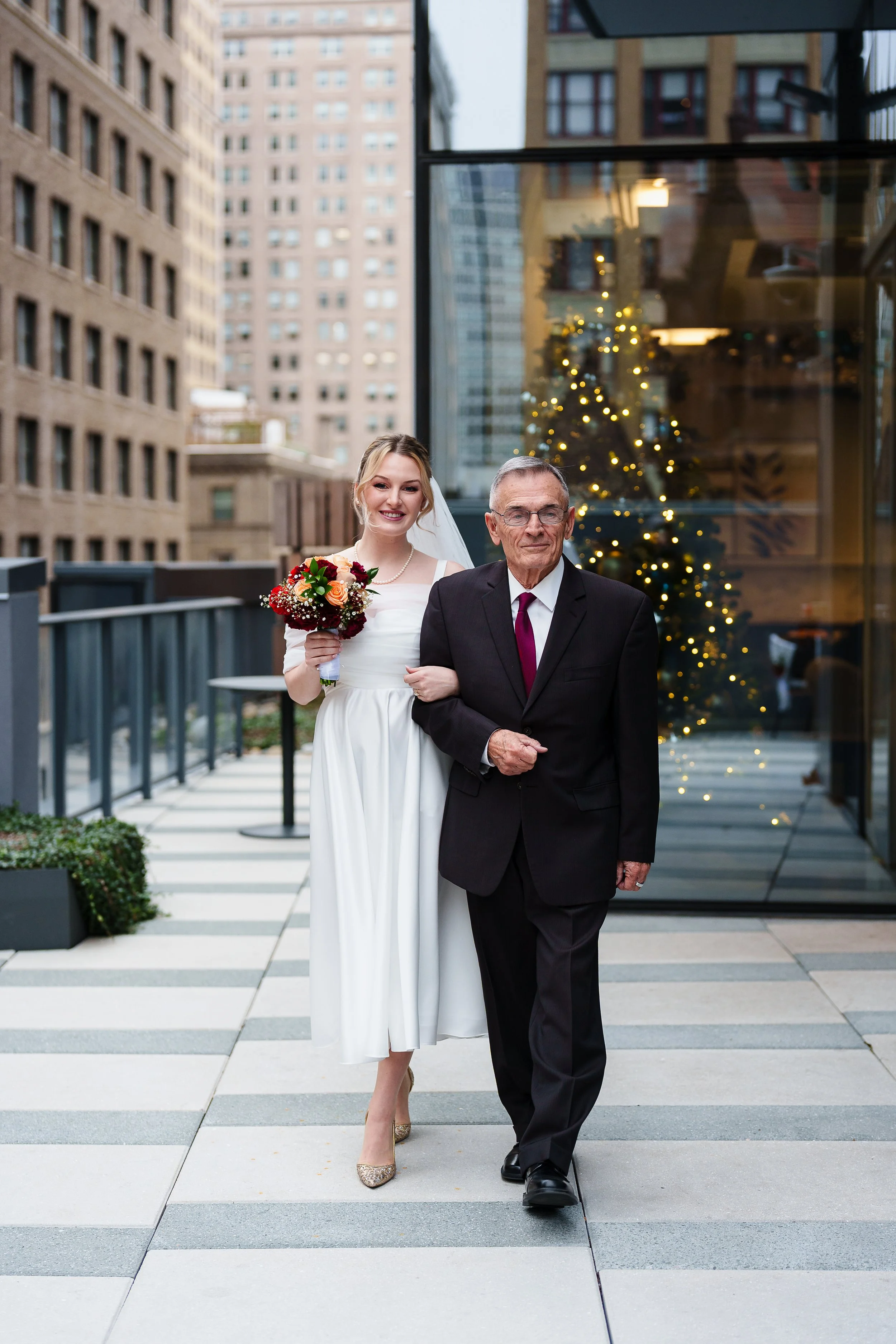 Dad walking bride down isle on Philadelphia rooftop. 