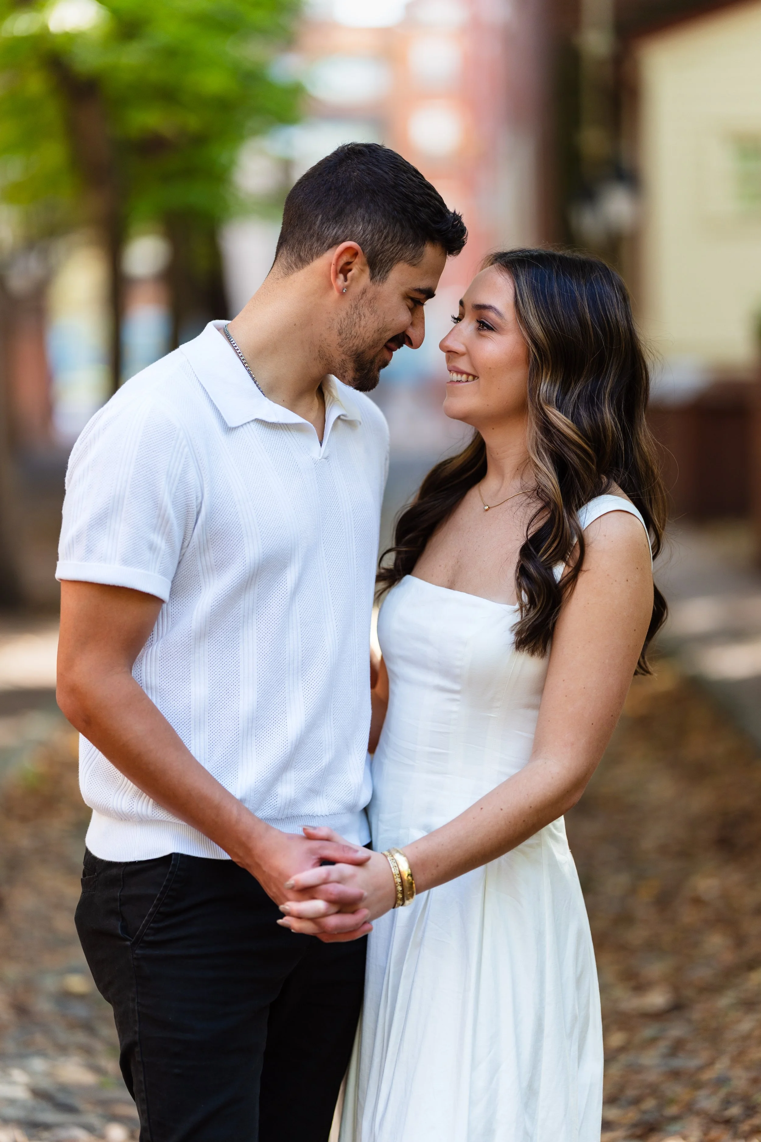 Couple holding hands looking at each other during Old City Philadelphia engagement session.