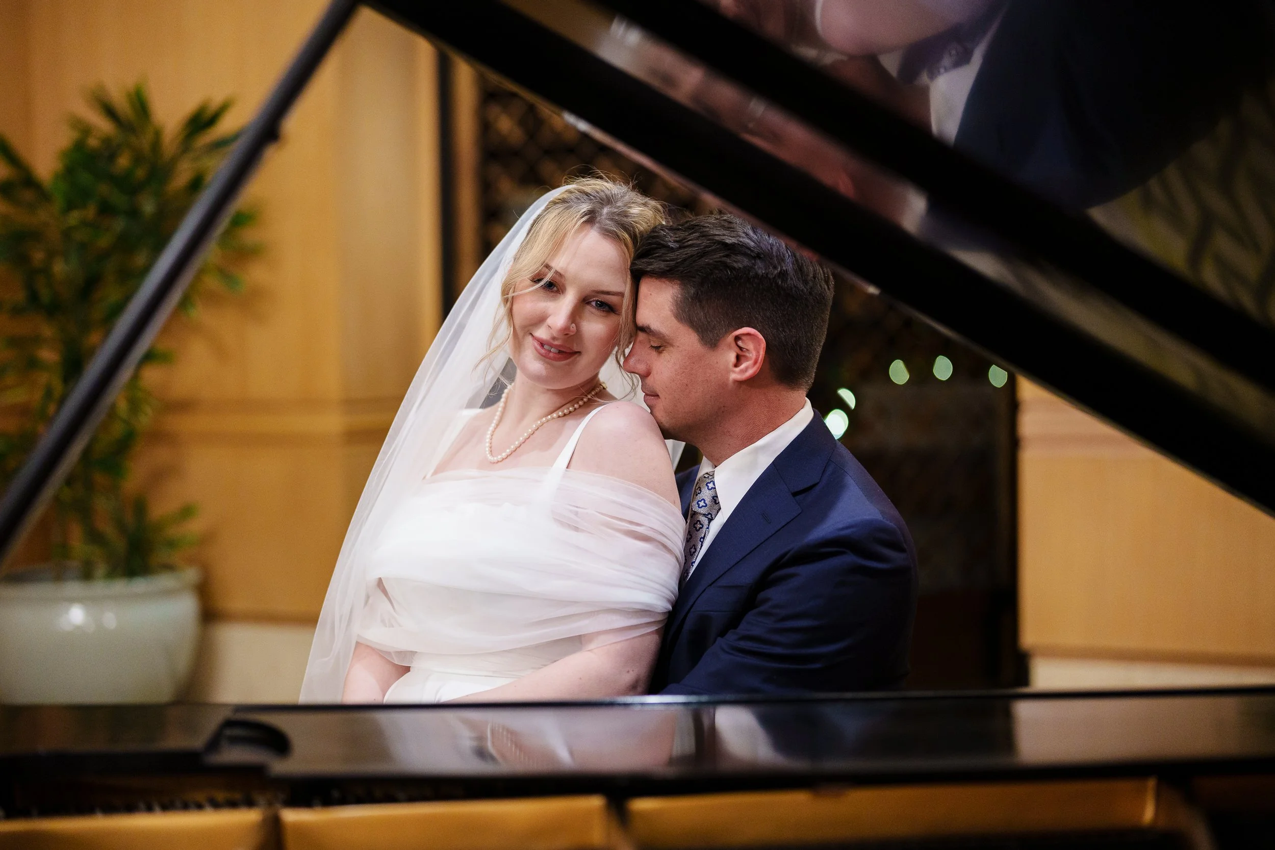 Bride and Groom framed by grand piano at Rittenhouse Hotel in Philadelphia, PA. 