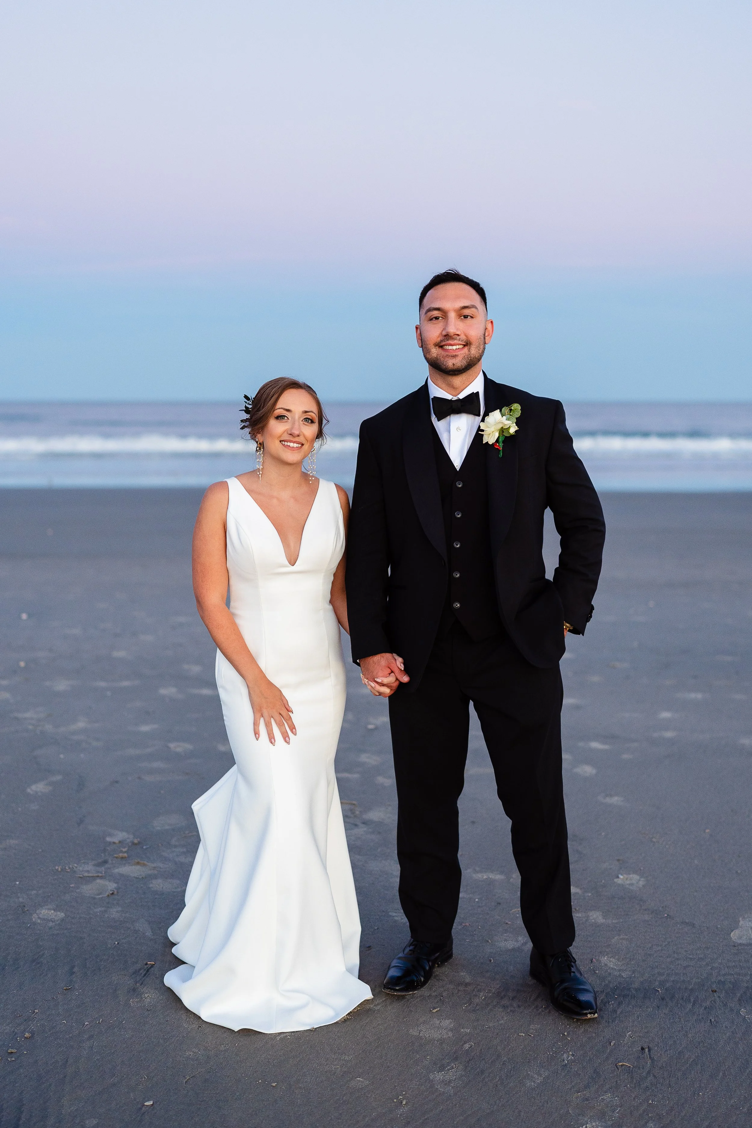 Bride and Groom standing side by side for couples portraits on Stone Harbor Beach in Stone Harbor New Jersey. 