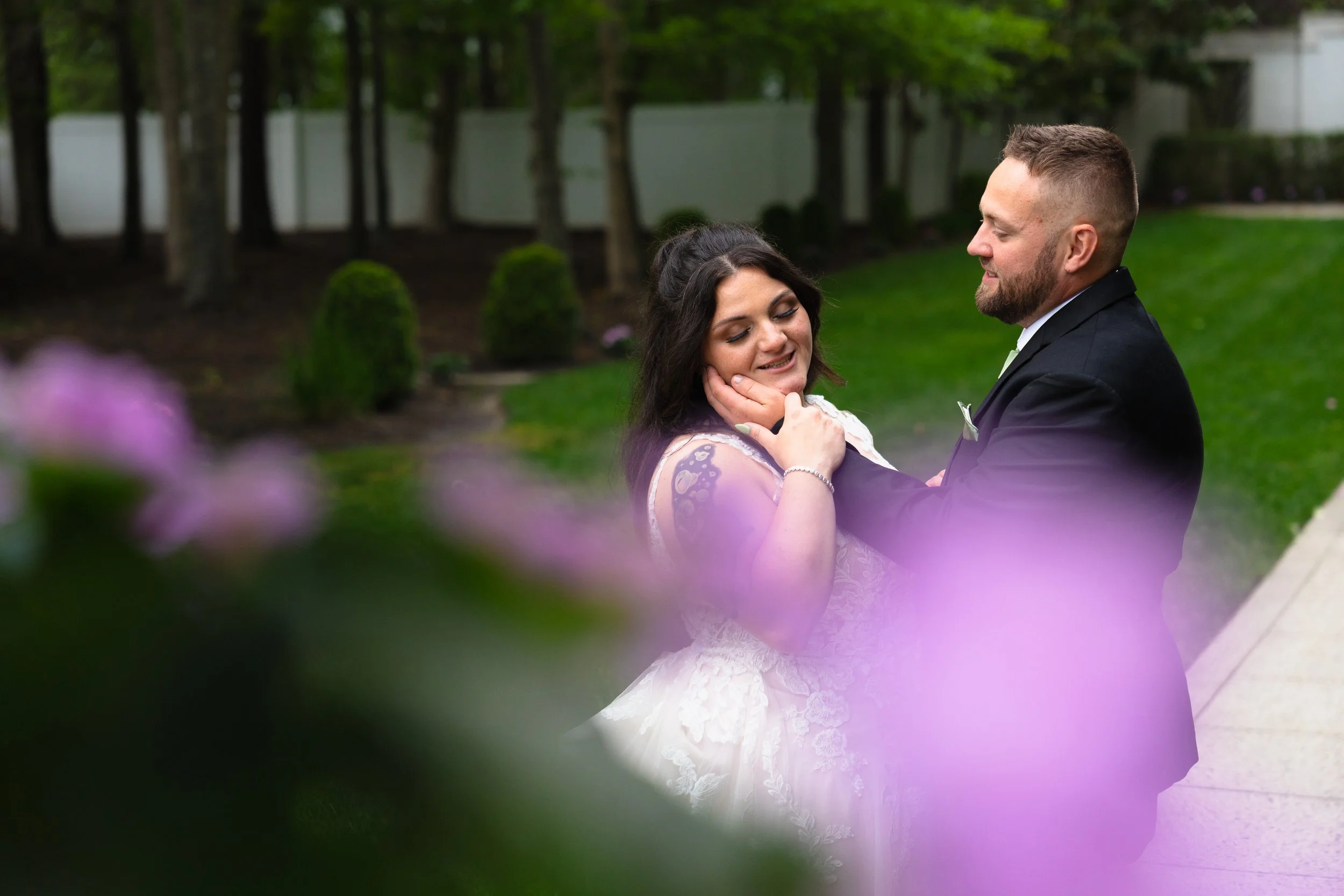 Bride and Groom posing for wedding portraits framed by flowers at The Carriage House in Galloway, New Jersey. 
