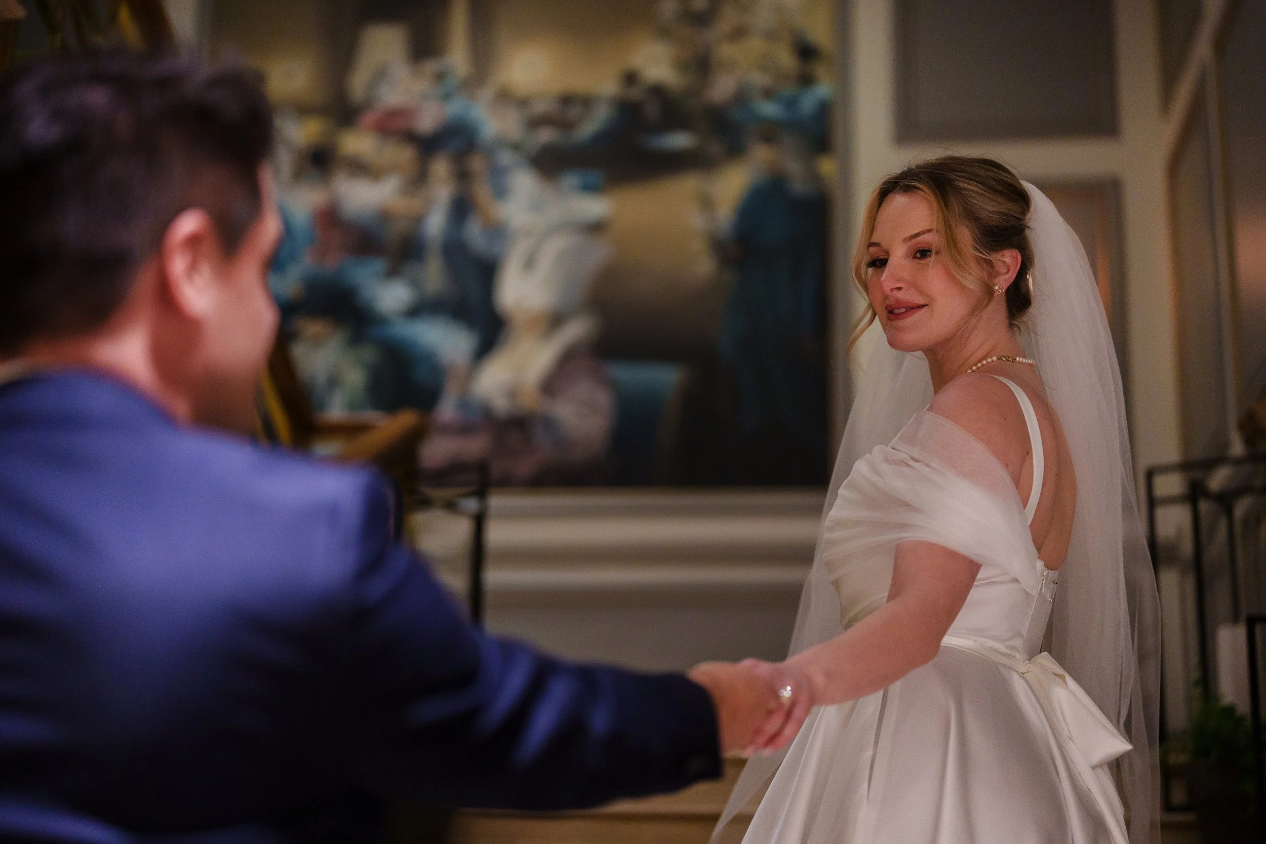 Bride looking back at groom as she leads him up stairs at The Rittenhouse Hotel in Philadelphia, PA