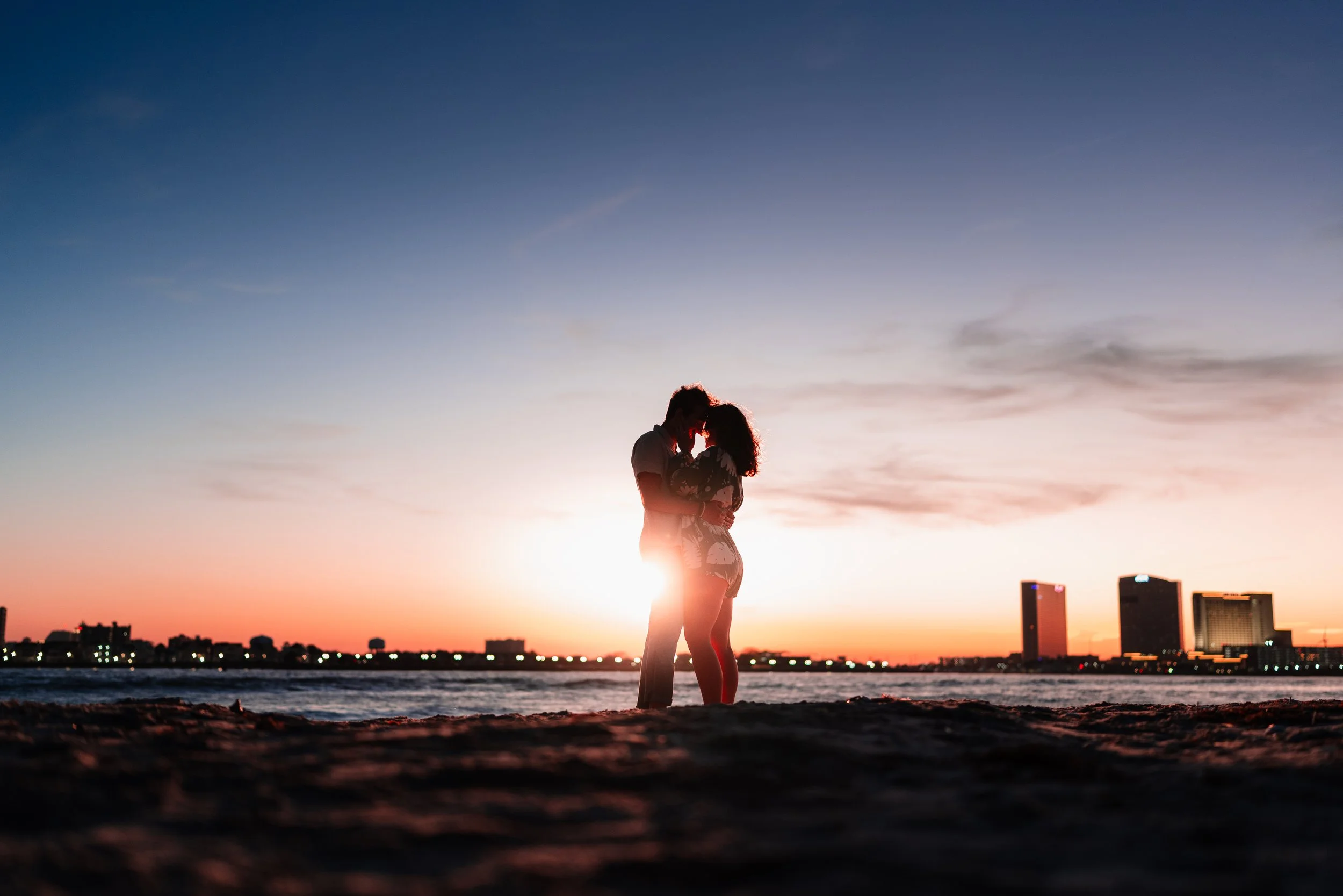 Couple posing in front of Sunset during proposal in Brigantine New Jersey. Outside of Atlantic City.