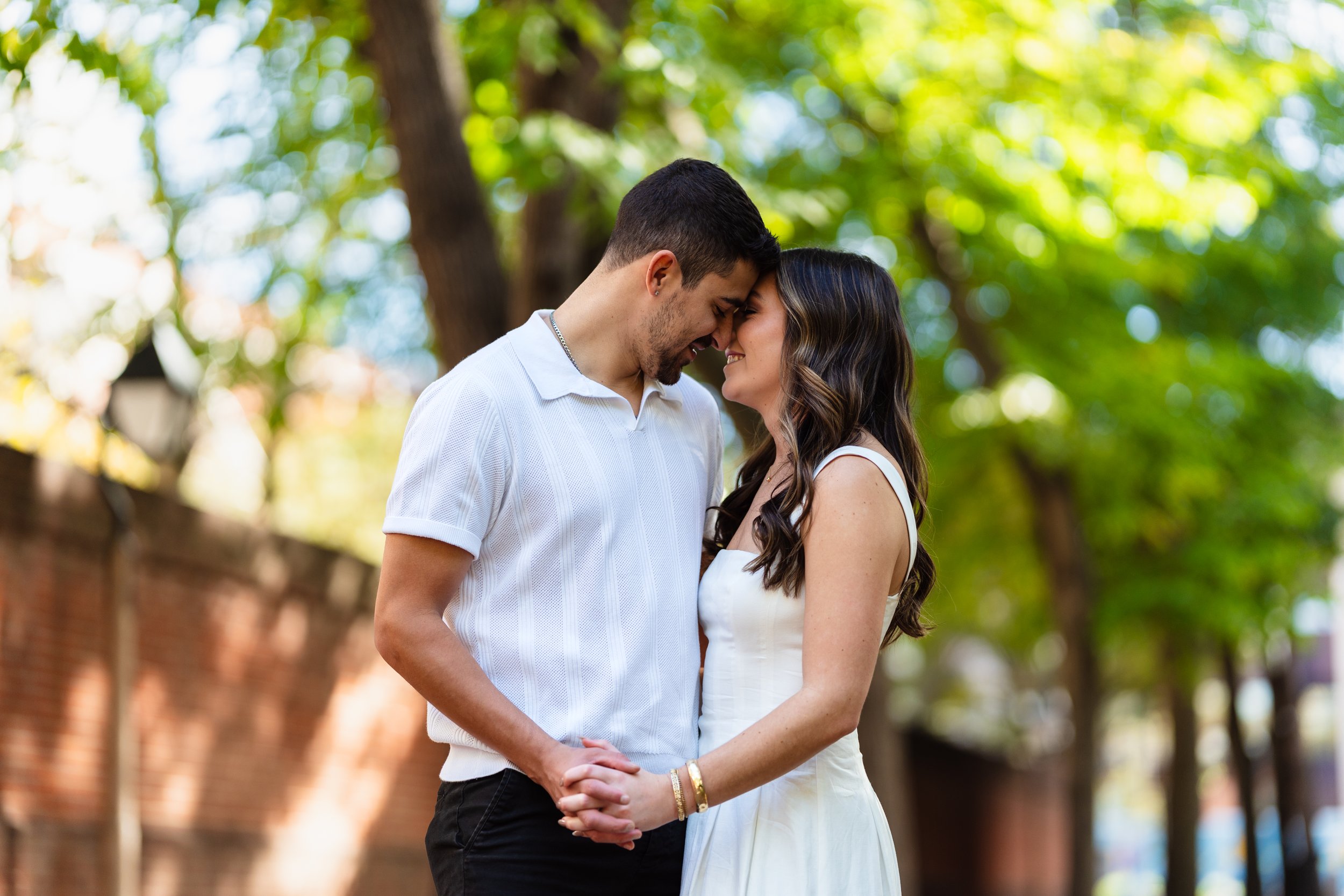 Couple holding hands embracing during engagement session in Old City Philadelphia at Merchant Exchange Building