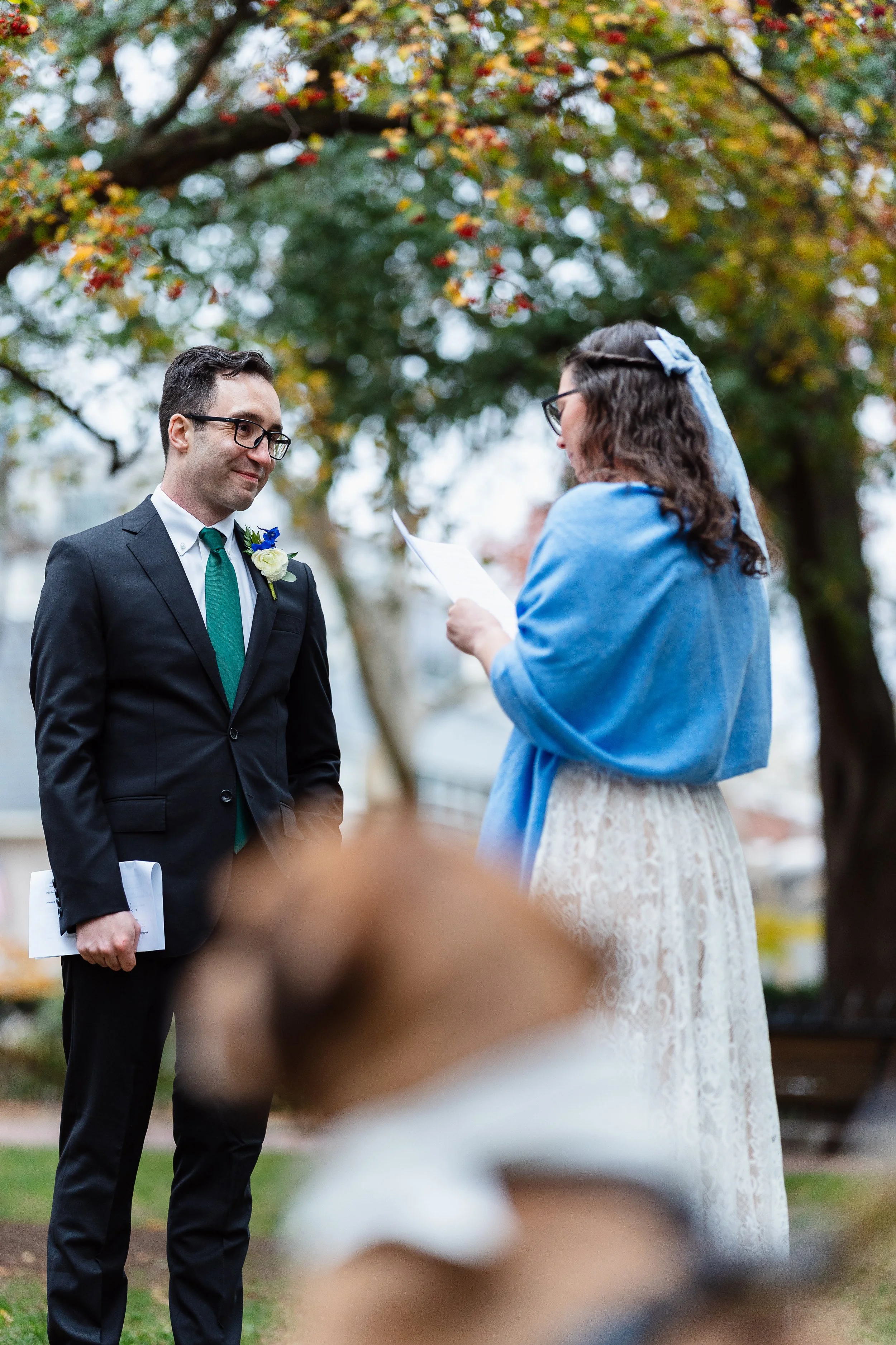 Groom happily listening to brides vows during Self-Uniting Ceremony in Fitler Square Park in Philadelphia, PA. 