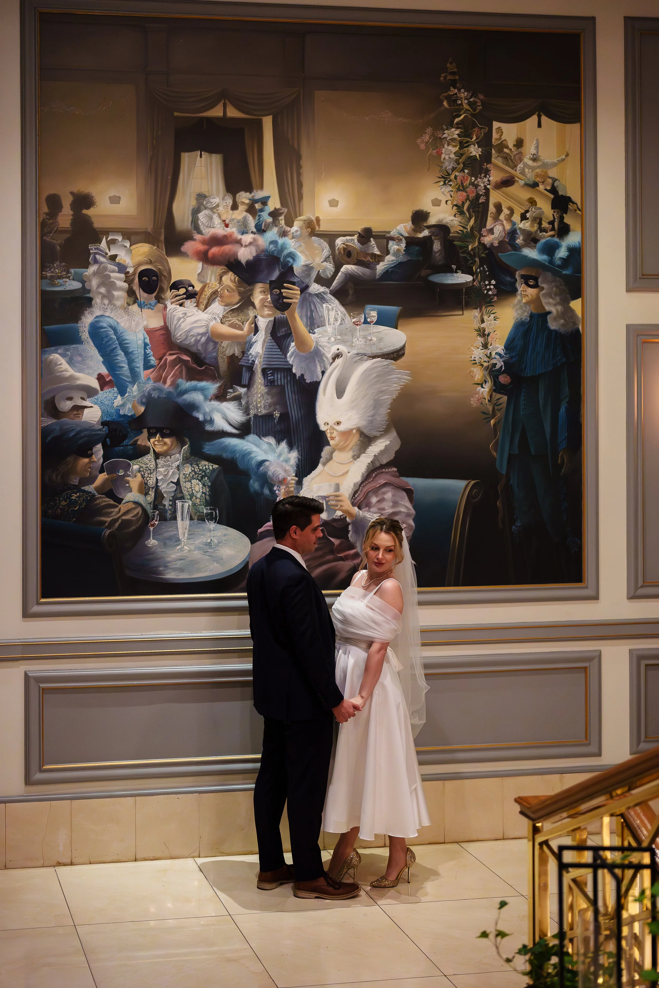 Bride and Groom holding hands in front of mural at Rittenhouse Hotel in Philadelphia, PA. 
