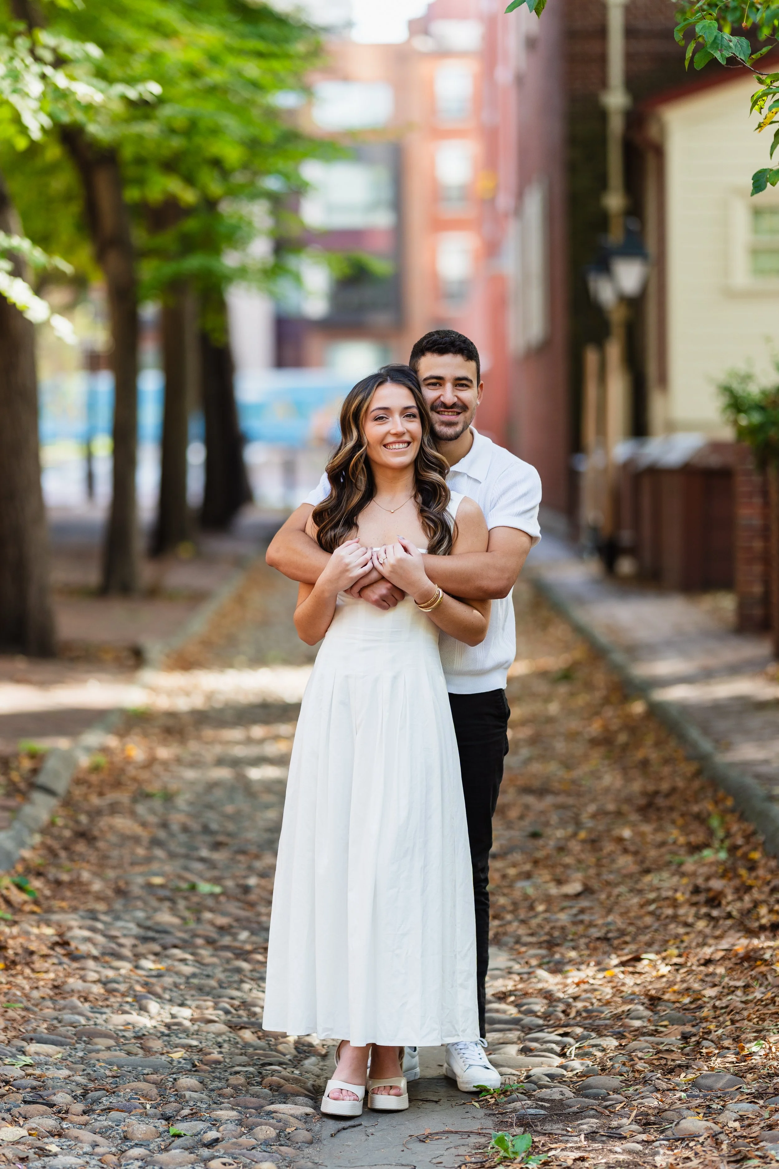 Couple embracing during their engagement session in Old City, Philadelphia. Location Merchant Exchange Building.
