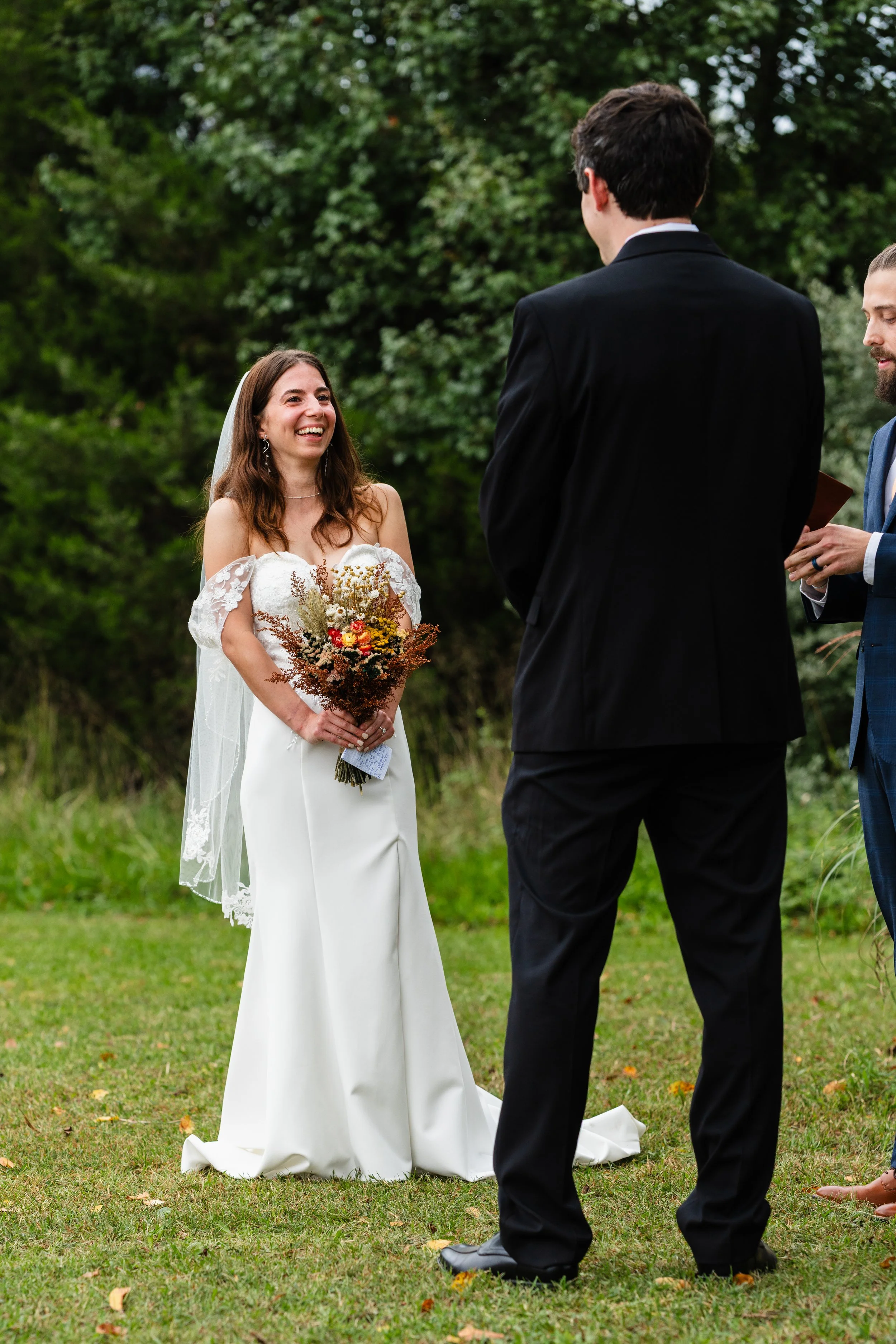 Bride pictured laughing during her backyard wedding Ceremony in New Jersey.